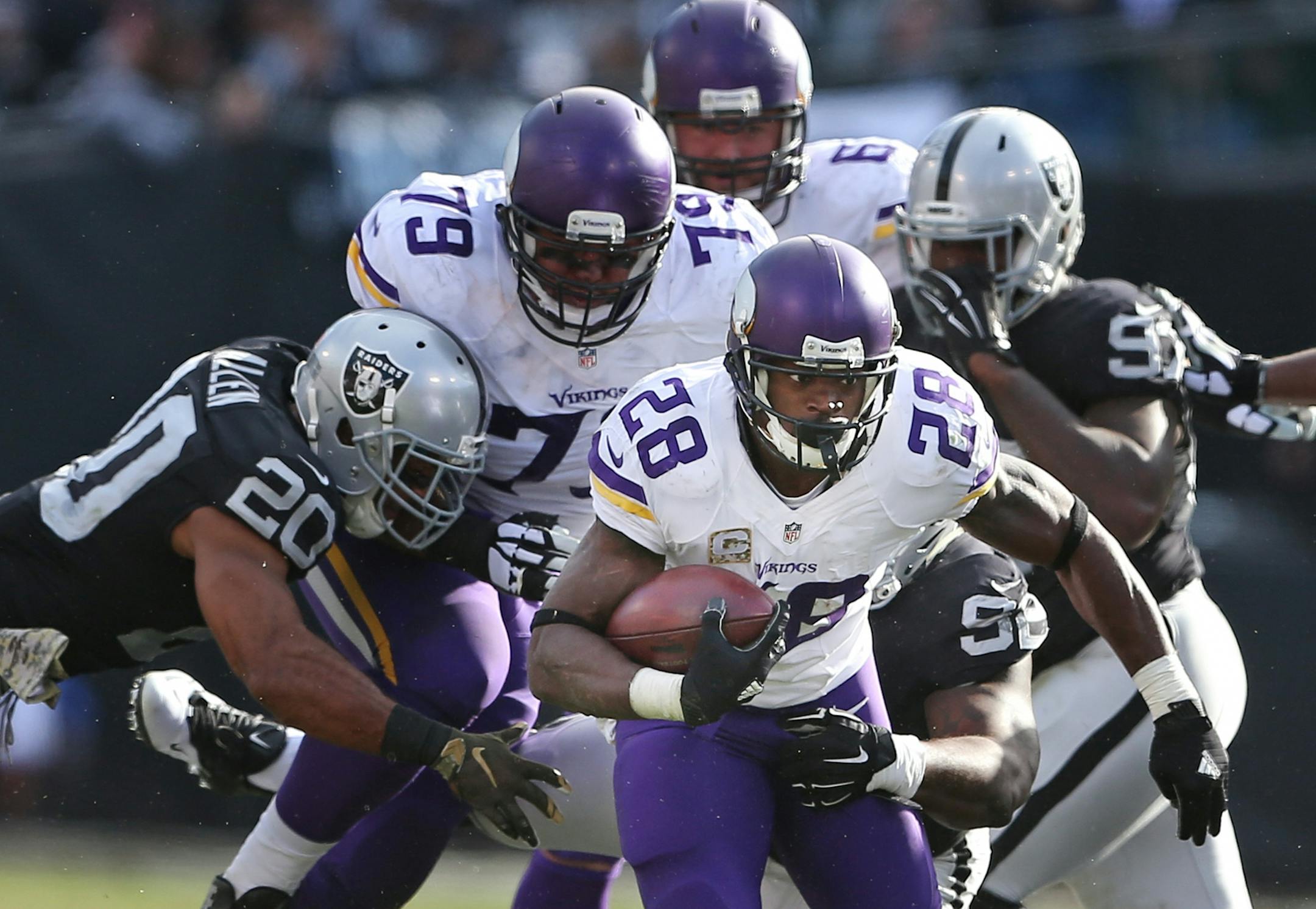 Minnesota Vikings running back Adrian Peterson (28) picked up a first down in the second quarter at the Oakland Coliseum Sunday November 15, 2015 in Oakland, CA.