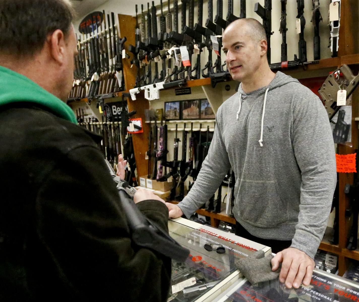 Wes Morosky, owner of Duke's Sport Shop. right, helps Ron Detka as he shops for a rifle on Friday, March 2, 2018, at his store in New Castle. Morosky said business has gone up recently, but that's thanks to the annual infusion of tax refund checks. Sales of firearms slowed dramatically after the election of President Donald Trump in 2016 allayed fears of a Democratic crackdown on gun owners. That trend continues, even with talk of gun control in Congress following the massacre of 17 people at a