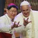 Filipino Cardinal Luis Antonio Tagle, left, shows Pope Francis how to give the popular hand sign for "I love you" at the Mall of Asia arena in Manila,