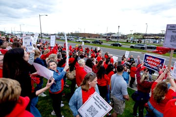 Demonstrators stood along Kenwood Trail during a rally before a school board meeting at the Lakeville District Office on Tuesday in Lakeville.