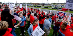 Demonstrators stood along Kenwood Trail during a rally before a school board meeting at the Lakeville District Office on Tuesday in Lakeville.