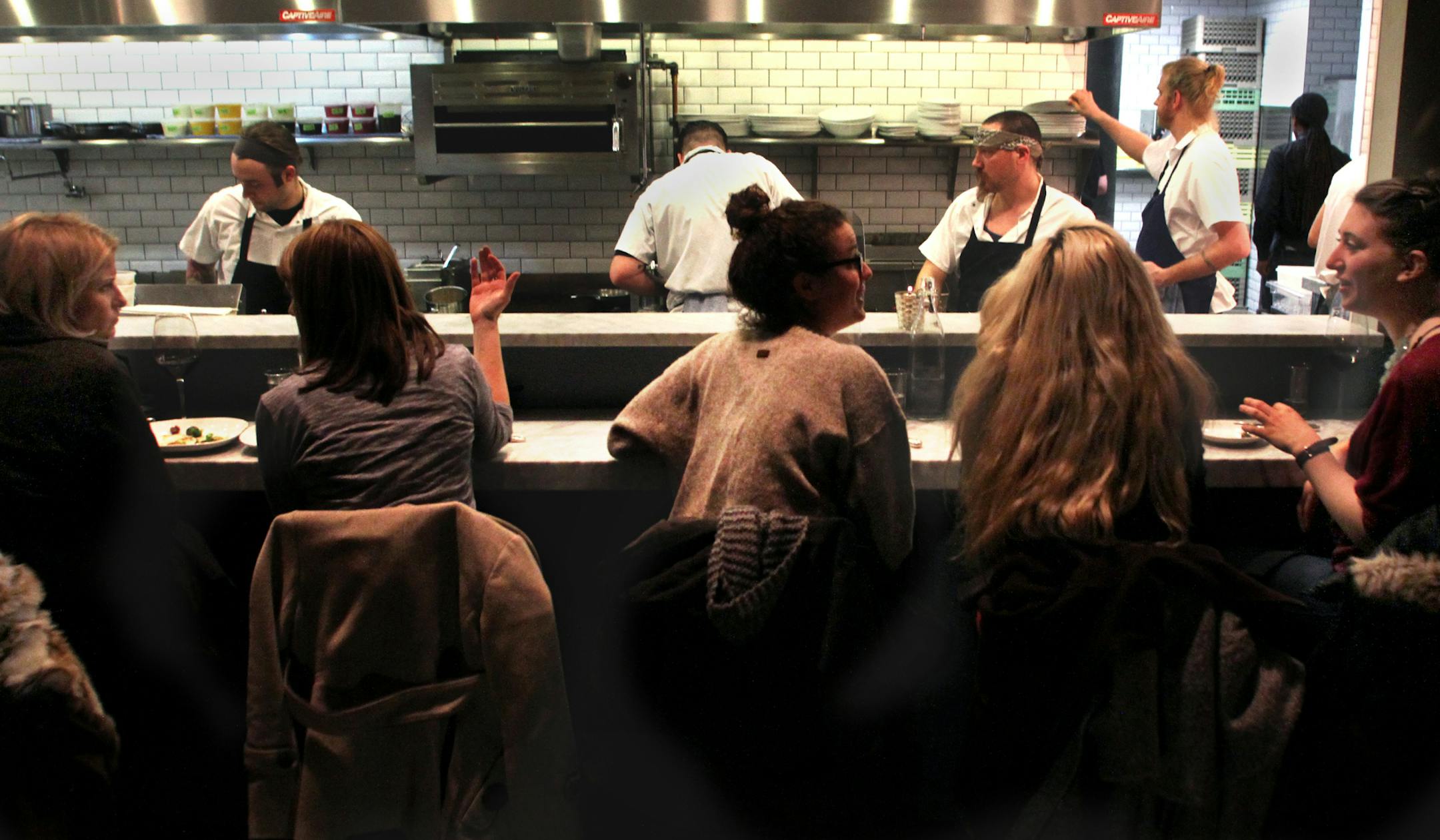 Customers sat next to the busy kitchen at Borough on Febuary 8, 2013. Borough is a popular new restaurant in the North Loop of Minneapolis. ] NICOLA LOSIK* nicola.losik@startribune.com ORG XMIT: MIN1302102208470709