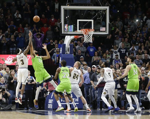 Minnesota Timberwolves center Karl-Anthony Towns (32) and Denver Nuggets forward Torrey Craig (3) go for a rebound in the final seconds of an NBA bask
