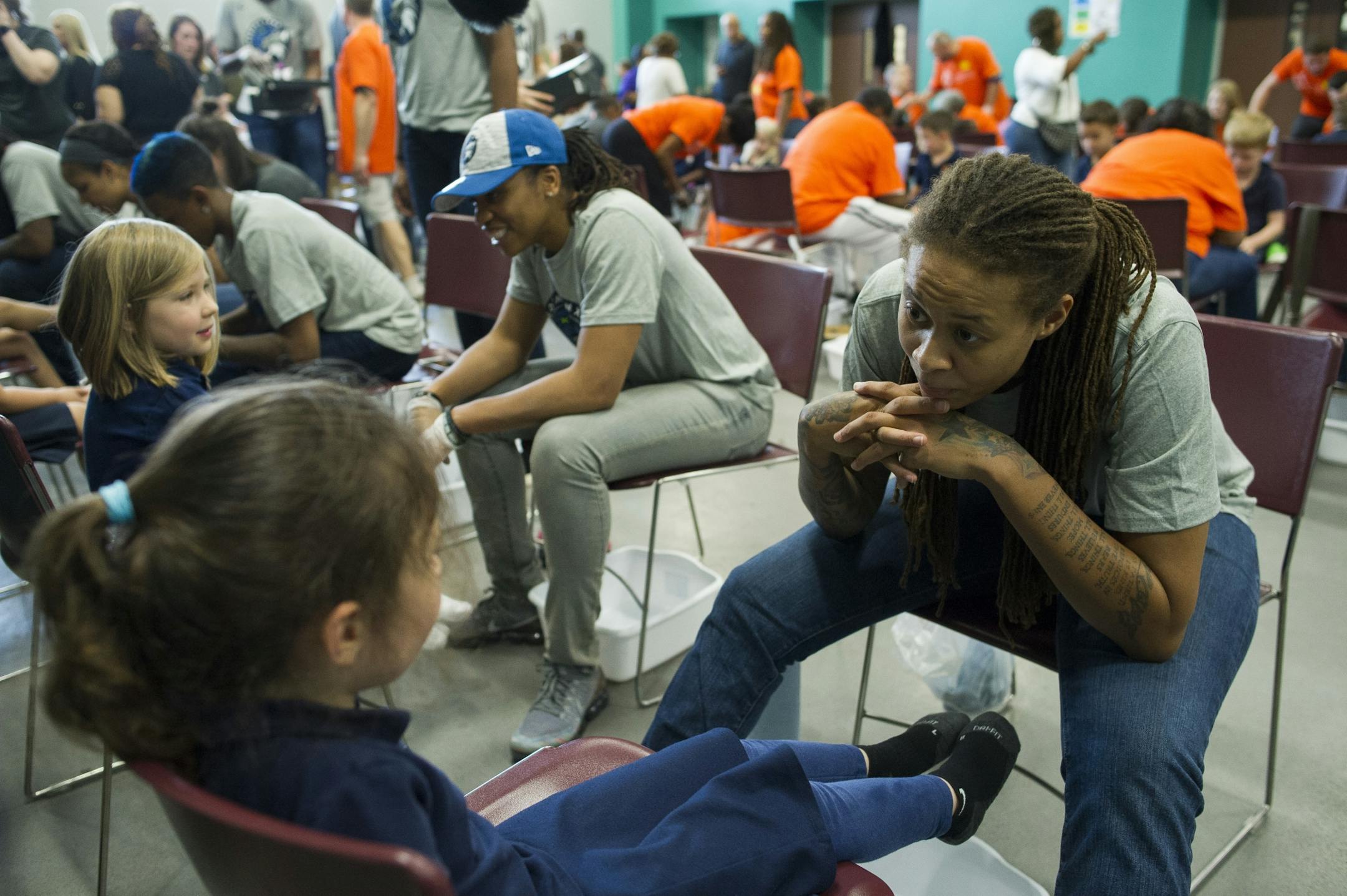 WNBA Champion Minnesota Lynx guard Seimone Augustus talks with a student before washing her feet at Payne Elementary School in Washington, Wednesday, June 6, 2018. Payne Elementary has the highest homeless student population in the district.