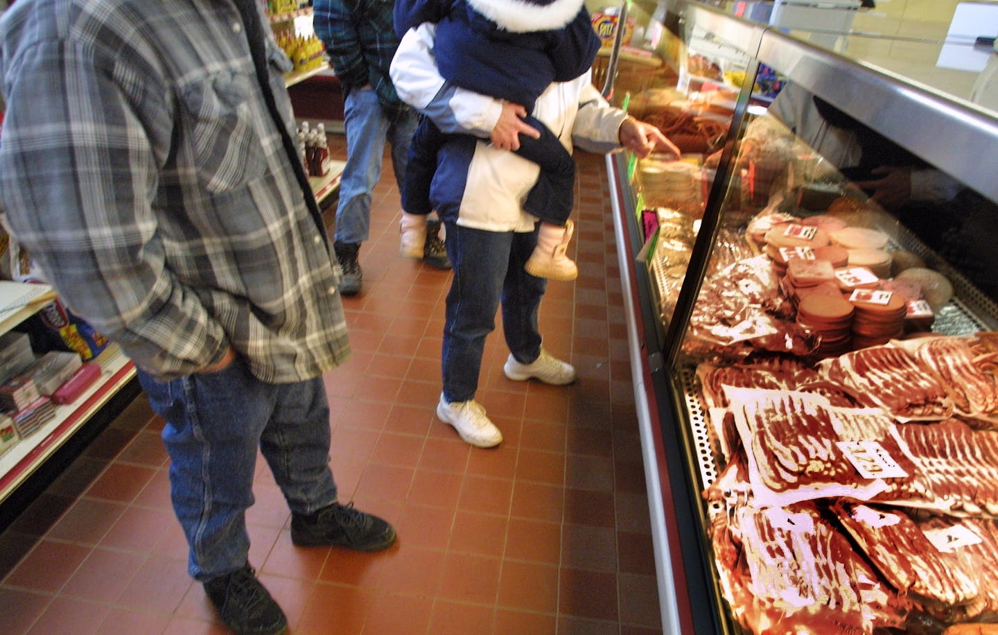 THIELEN MEATS, PIERZ, MN - FRI - 11/15/2002 - Guys, gals, women with babes in arms line up to point out their choices. // bacon //