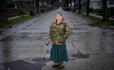 Giovanna Johnson stands next to the sewer cover that blows out whenever they have a lot of rain in her neighborhood on Friday in Minneapolis. Two year