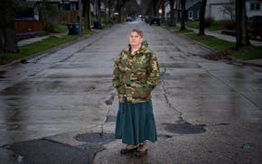 Giovanna Johnson stands next to the sewer cover that blows out whenever they have a lot of rain in her neighborhood on Friday in Minneapolis. Two year