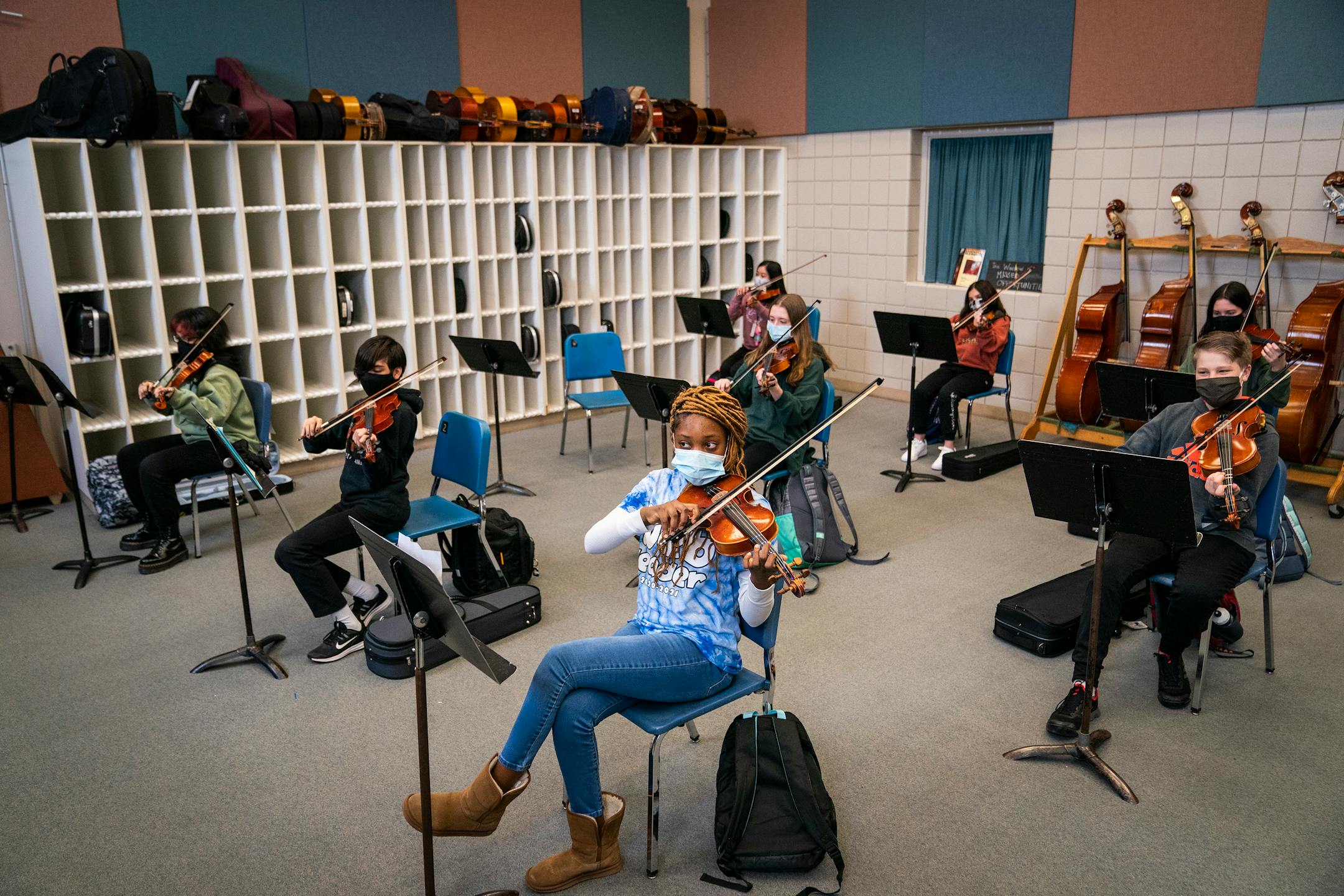 Adrianna Togba, center, and the rest of the eighth grade orchestra get ready to play a song during class at Jackson Middle School in Champlin.
