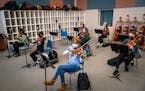Adrianna Togba, center, and the rest of the eighth grade orchestra get ready to play a song during class at Jackson Middle School in Champlin.