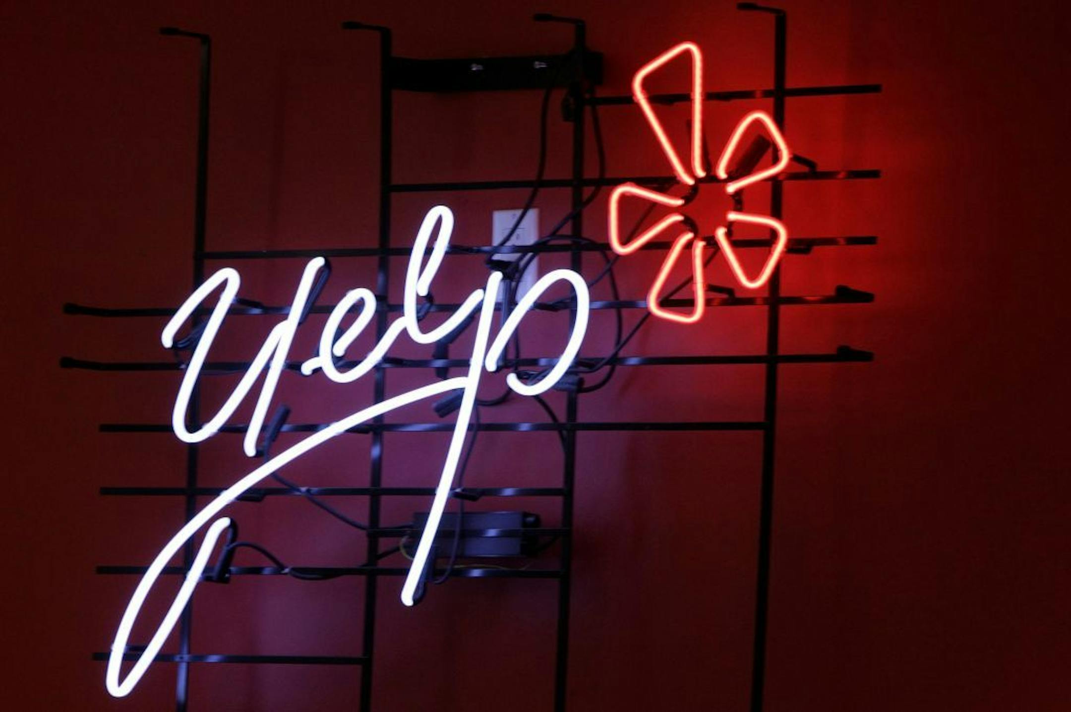 FILE - In this Oct. 26, 2011 file photo, the logo of the online reviews website Yelp is shown in neon on a wall at the company's new Manhattan offices in New York. Online reviews site Yelp is expected to price its initial public offering of stock on Thursday , March 1, 2012, and become the latest in a long line of social websites going public.
