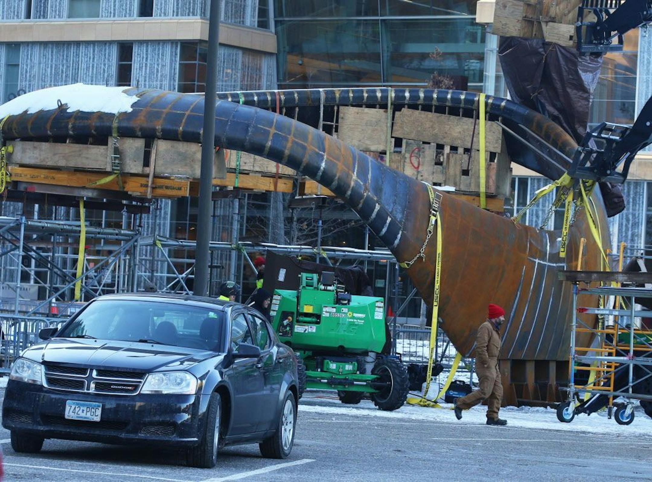 Artist Tristan Al-Haddad walks by his creation "Nimbus," an18,000-pound sculpture, as it was being assembled across from the Minneapolis Central Library and seen Friday, Dec. 7, 2018, on the Nicollet Mall.