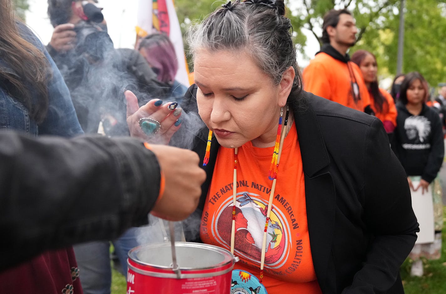 Christine Diindiisi McCleave wafted cedar smoke Friday at Cedar Field Park in Minneapolis.