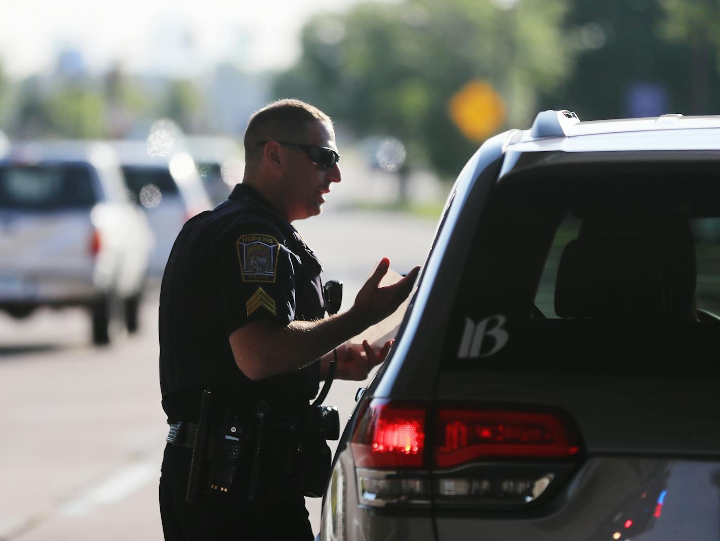 Hopkins police officer Sgt. Mike Glassberg was out patrolling Hopkins roads looking for violators on the first day of the new hands free law Thursday. Here, he issued a ticket to a driver who had been holding a cell phone while driving near Highway 169 and Excelsior Blvd.