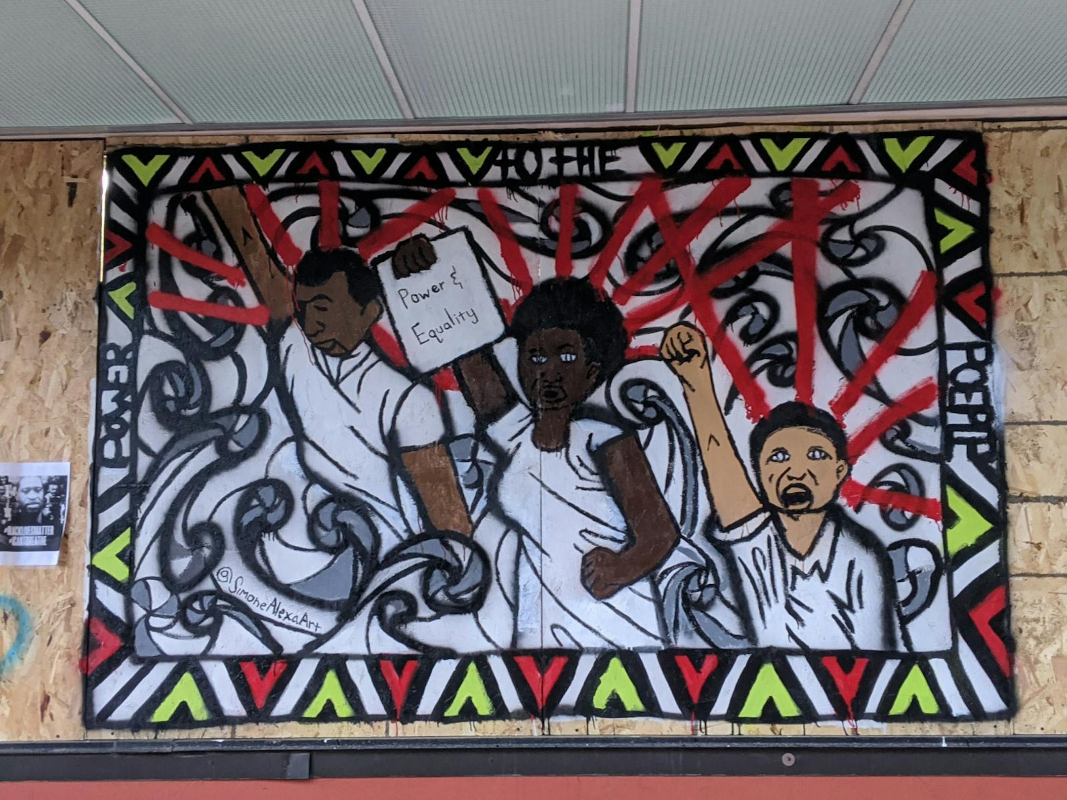 A plywood mural at Third Avenue Foods (1905 3rd Ave. S, Mpls) by @SimoneAlexaArt portrays people rising up in solidarity. Photo: Alicia Eler George Floyd murals