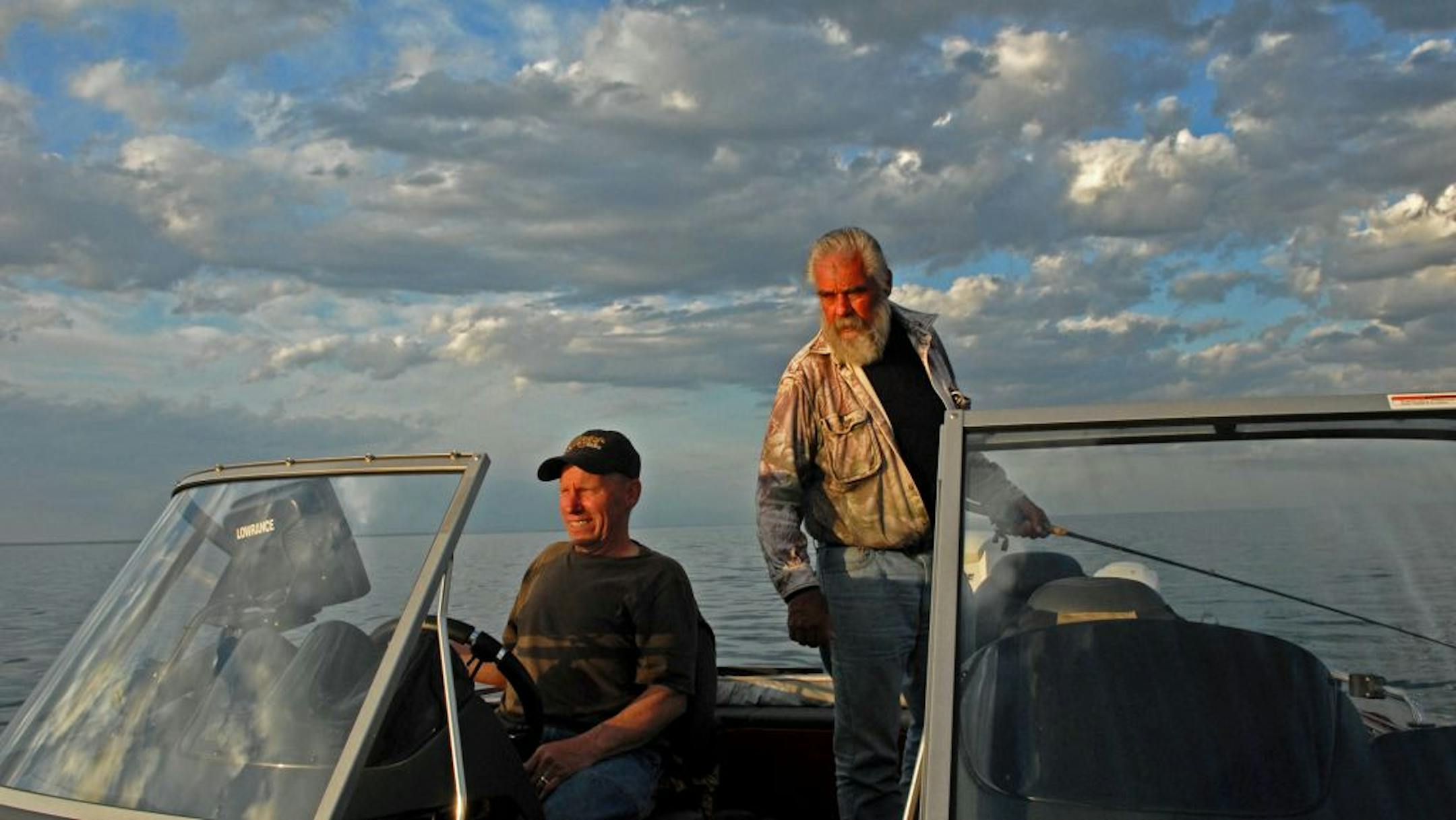 Lrry Blaske, left, and Dick (Griz) Grzywinski watch Blaske's depth finder and GPS to make sure they're fishing over the Mille Lacs structure they believe holds walleyes.