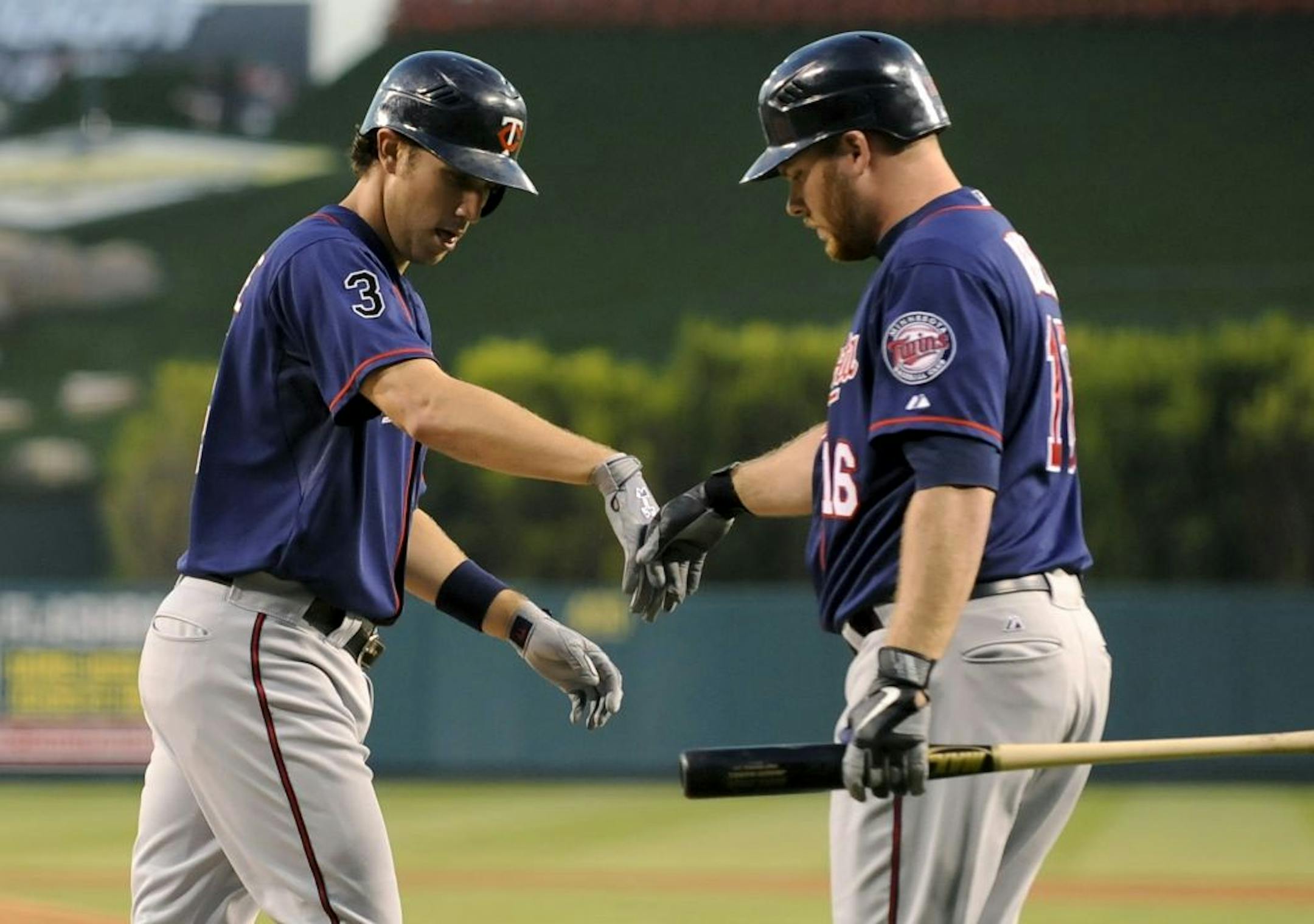 Minnesota Twins' Trevor Plouffe, left, celebrates his solo home run with teammate Jason Kubel, right, in the first inning of a baseball game against the Los Angeles Angels, Friday, Sept. 2, 2011, in Anaheim, Calif.