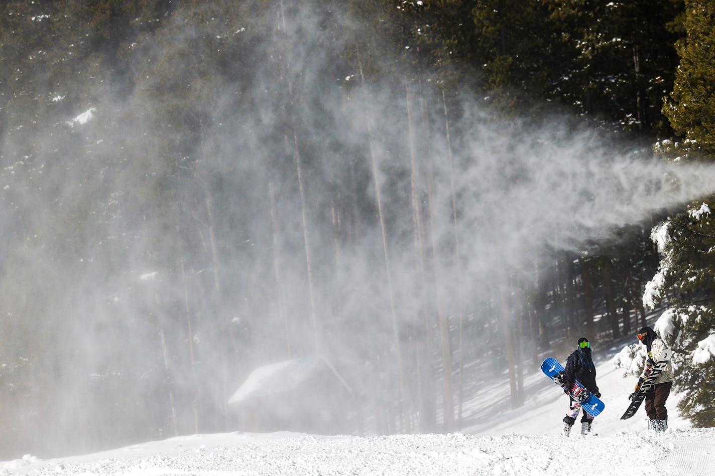 People walk under a snow making machine on opening day at Breckenridge Ski Resort on Nov. 13, 2020, in Breckenridge, Colorado. Colorado's ski season is underway, with most resorts set to open in the coming weeks. (Michael Ciaglo/Getty Images/TNS)