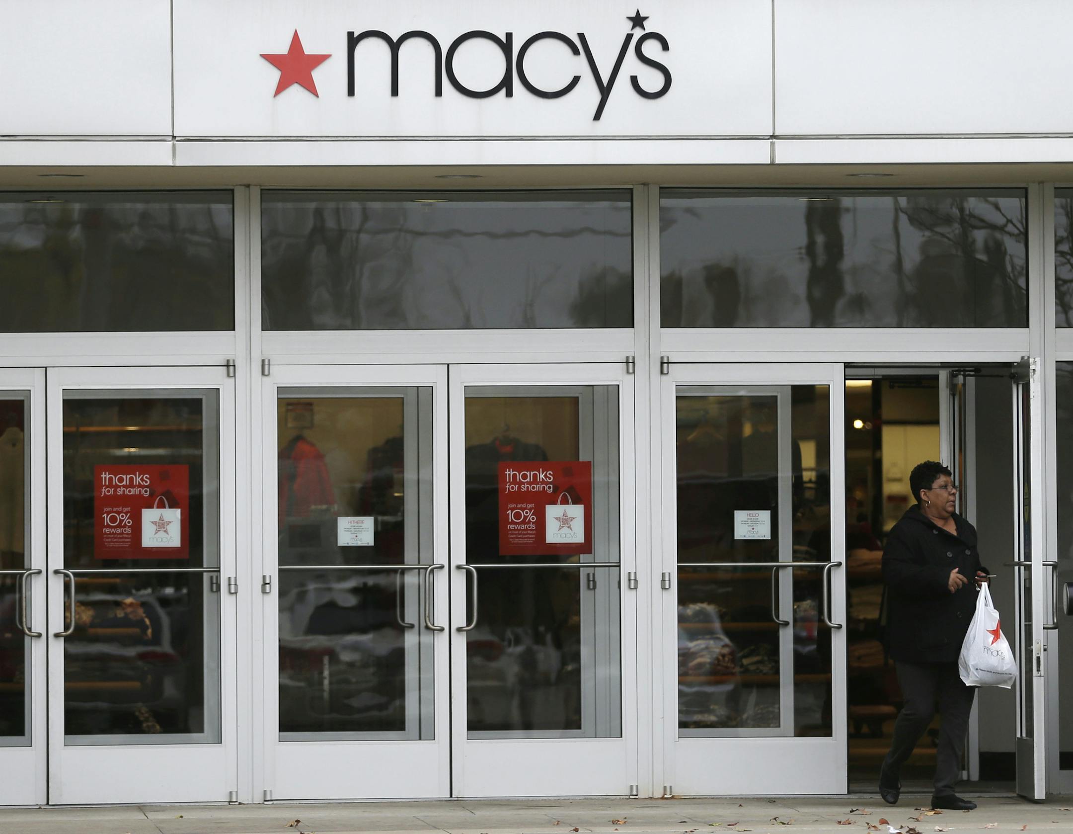 In this Monday, Nov. 11, 2013, photo, a woman walks out of Macy's department store in University Heights, Ohio. Macy's reports quarterly earnings on Wednesday, Nov. 13, 2013. (AP Photo/Tony Dejak)