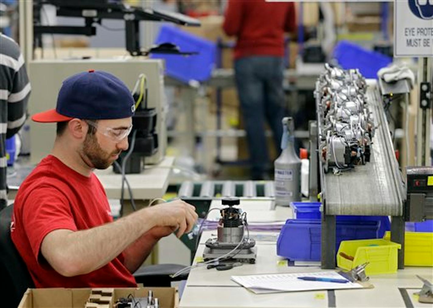 In this April 15, 2014 photo, Anthony Zingale wires blender motors at the Vitamix manufacturing facility in Strongsville, Ohio. A measure of the U.S. economy's health rose in March for the third consecutive month, a sign of stronger growth after harsh winter weather caused the economy's pace to slow. (AP Photo/Mark Duncan)