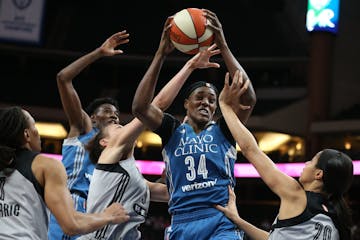 Lynx center Sylvia Fowles (34) pulled down a rebound over San Antonio forward Dearica Hamby left and Isabelle Harrison (20) on June 25