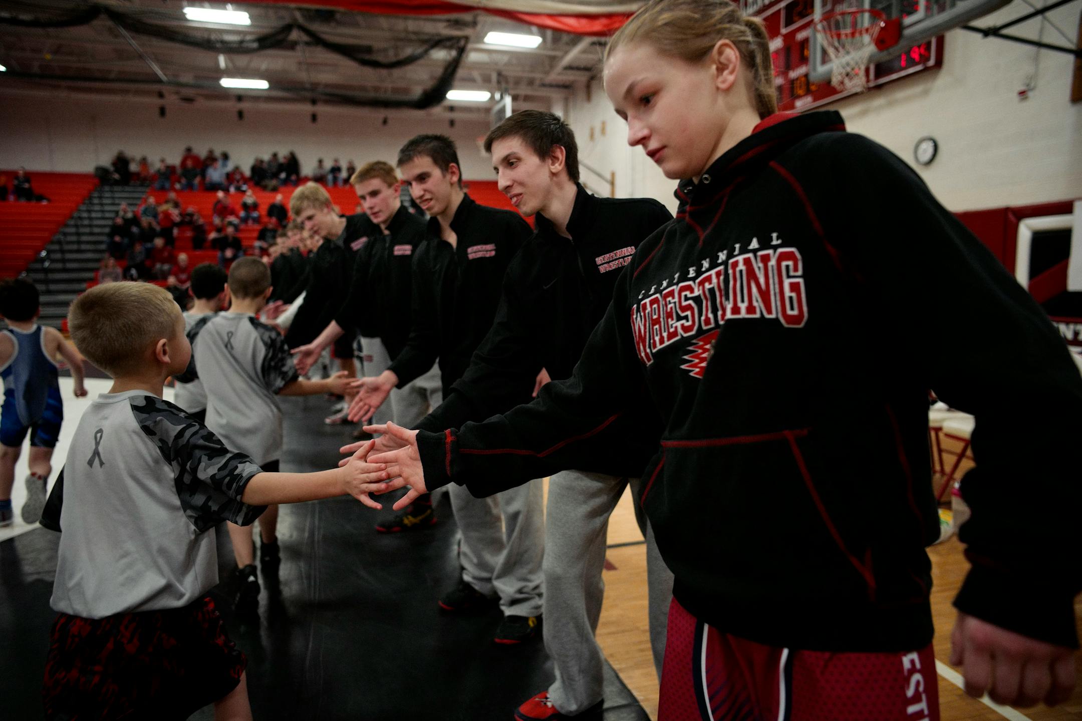 Emily Shilson and other wrestlers on Centennial's team greeted young athletes