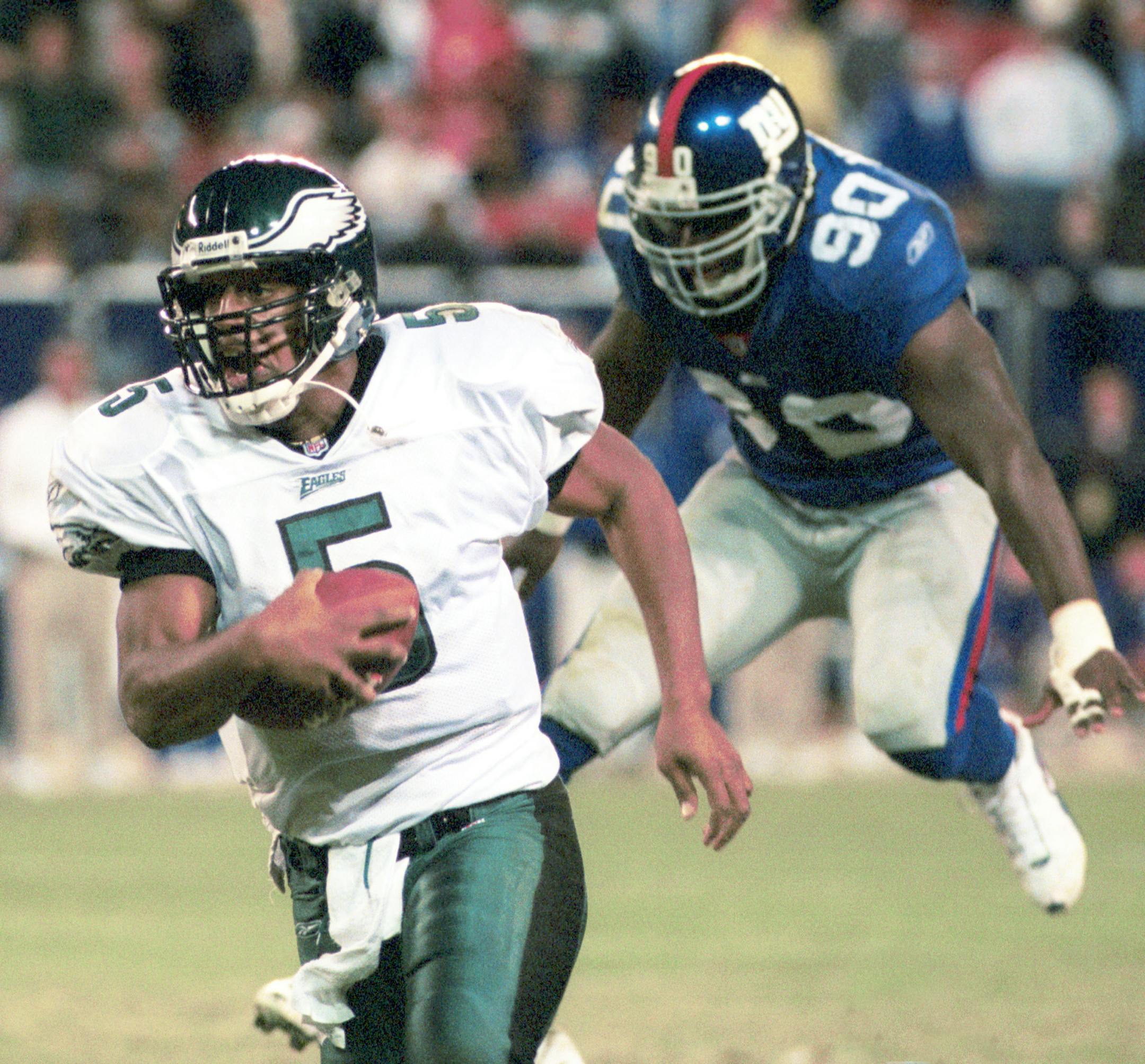 NJP2001102205 - 22 OCTOBER 2001 - EAST RUTHERFORD,NEW JERSEY, USA: Philadelphia Eagles quarterback Donovan McNabb out runs a leaping New York Giants defender (90) Kenny Holms. The Philadelphia Eagles defeated the New York Giants by a score of 10 to 9 on October 22, 2001 at Giants Stadium in East Rutherford, New Jersey. cc/ja/John Angelillo
