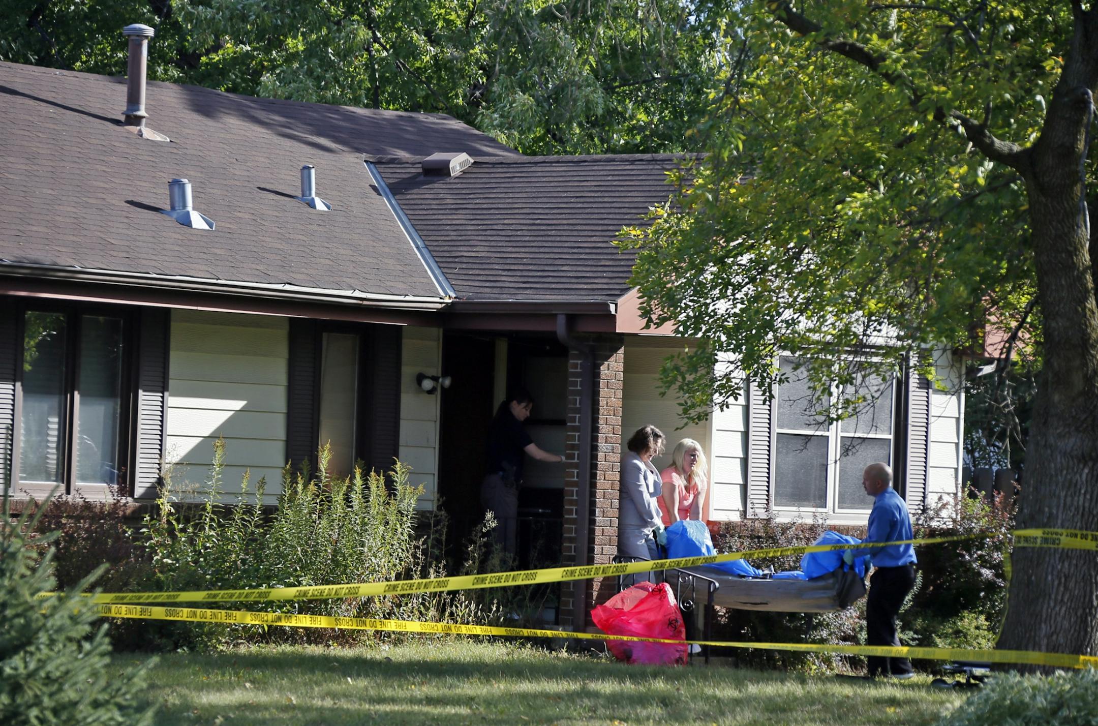 The body of one of the victims was removed from a Brooklyn Center home Monday morning. Reports indicated a man and his adult son were shot dead and the mohter wounded. [ Jerry Holt, Star Tribune, Brooklyn Center, MN 9/23/2013