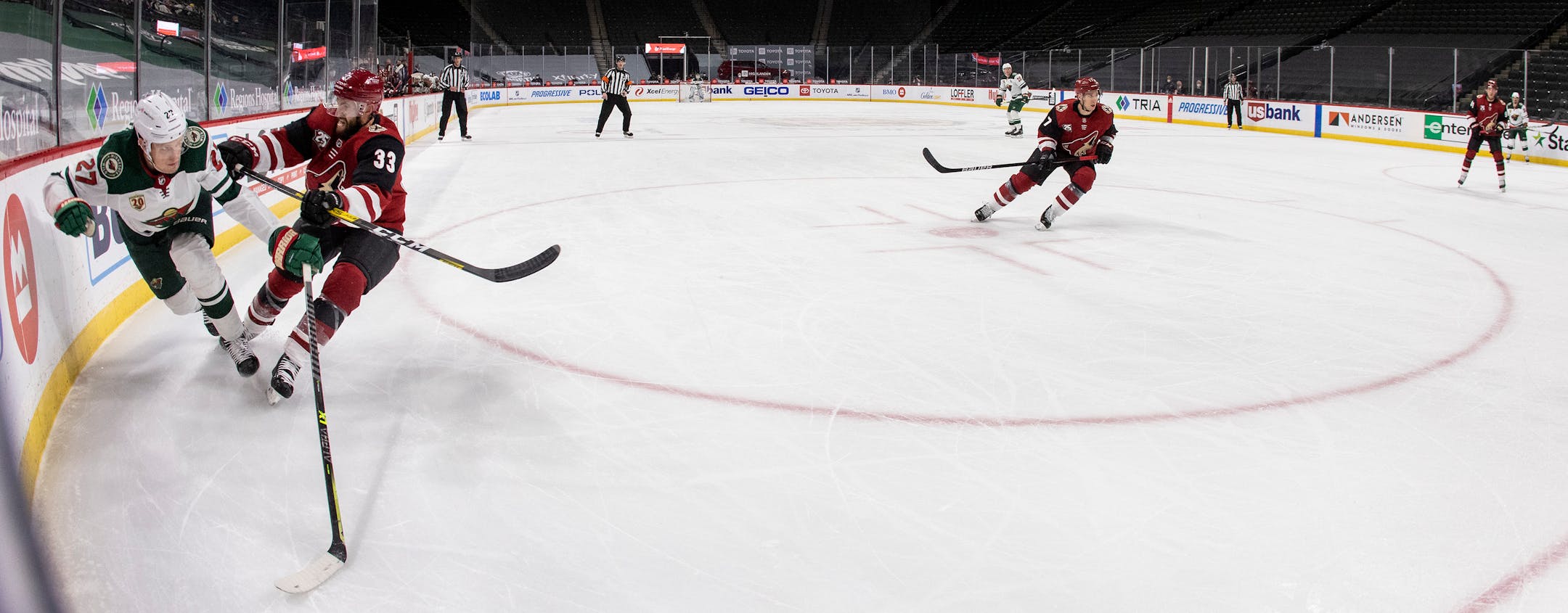 Nick Bjugstad (27) and Minnesota Wild and Alex Goligoski (33) of the Arizona Coyotes chased the puck in the first period.