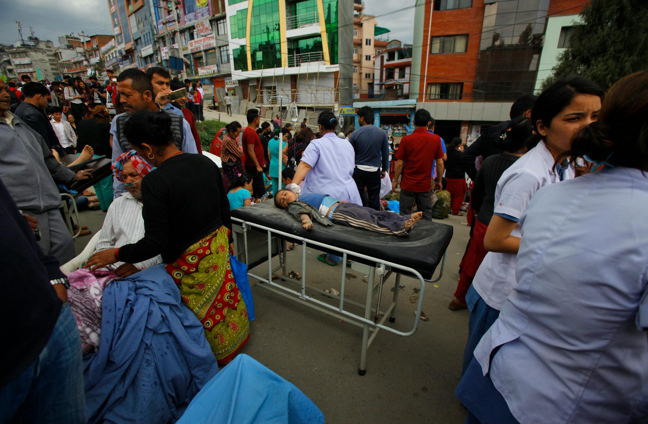 An injured child receives treatment outside Medicare Hospital in Kathmandu, Nepal, Saturday, April 25, 2015. A strong magnitude-7.9 earthquake shook Nepal's capital and the densely populated Kathmandu Valley before noon Saturday, causing extensive damage with toppled walls and collapsed buildings, officials said. (AP Photo/ Niranjan Shrestha)