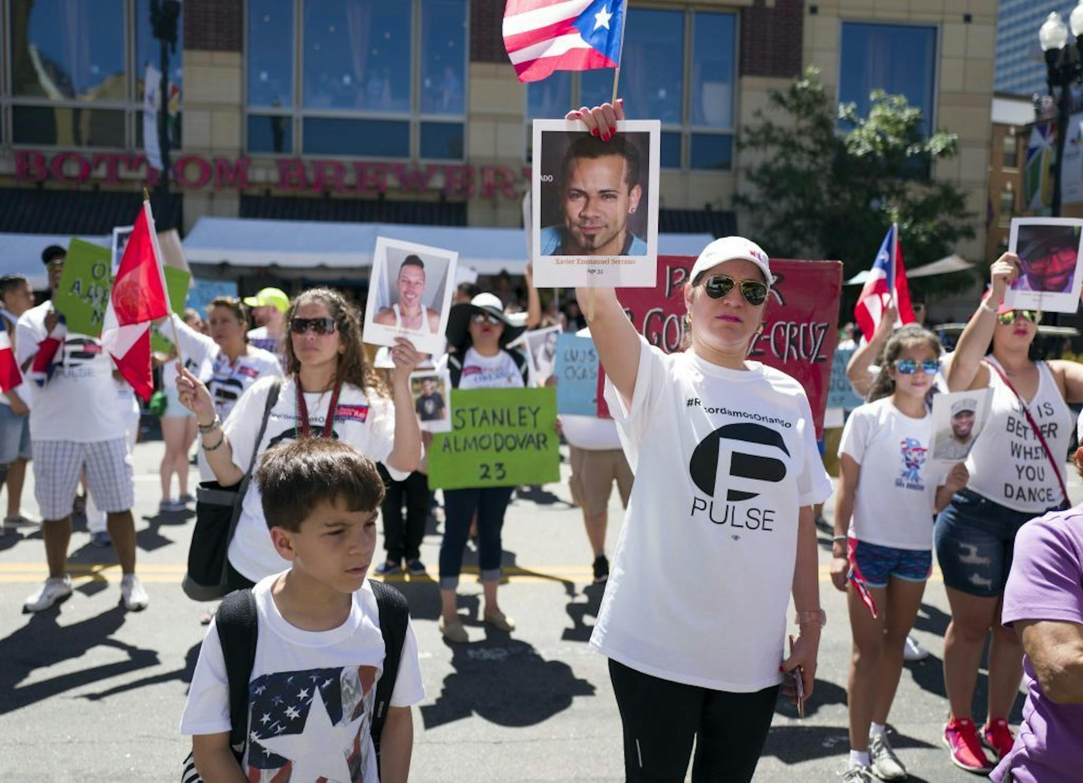 Yazmin Ramos of Puerto Rico held a photograph of one the 49 shooting victims from the Pulse Club in Orlando during the Pride parade Sunday June 26, 2016. in Minneapolis.
