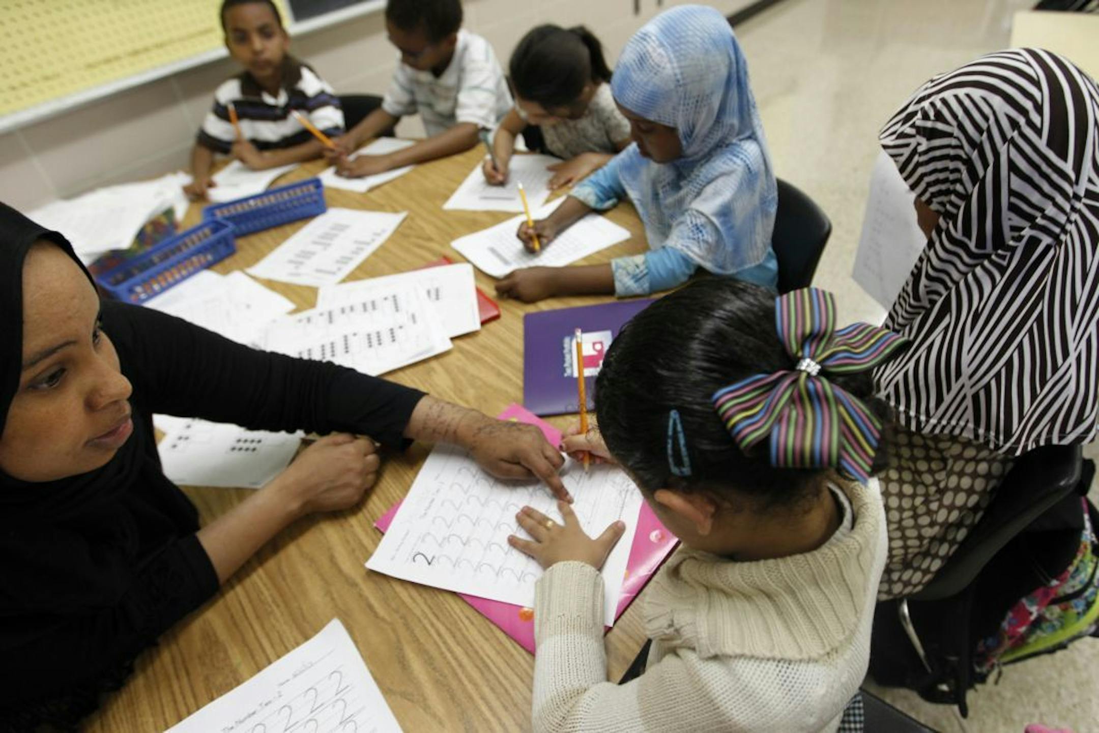 Teaching assistant Yasmin Mohammed helps students with some math exercises during summer school at Tarek ibn Ziyad Academy.