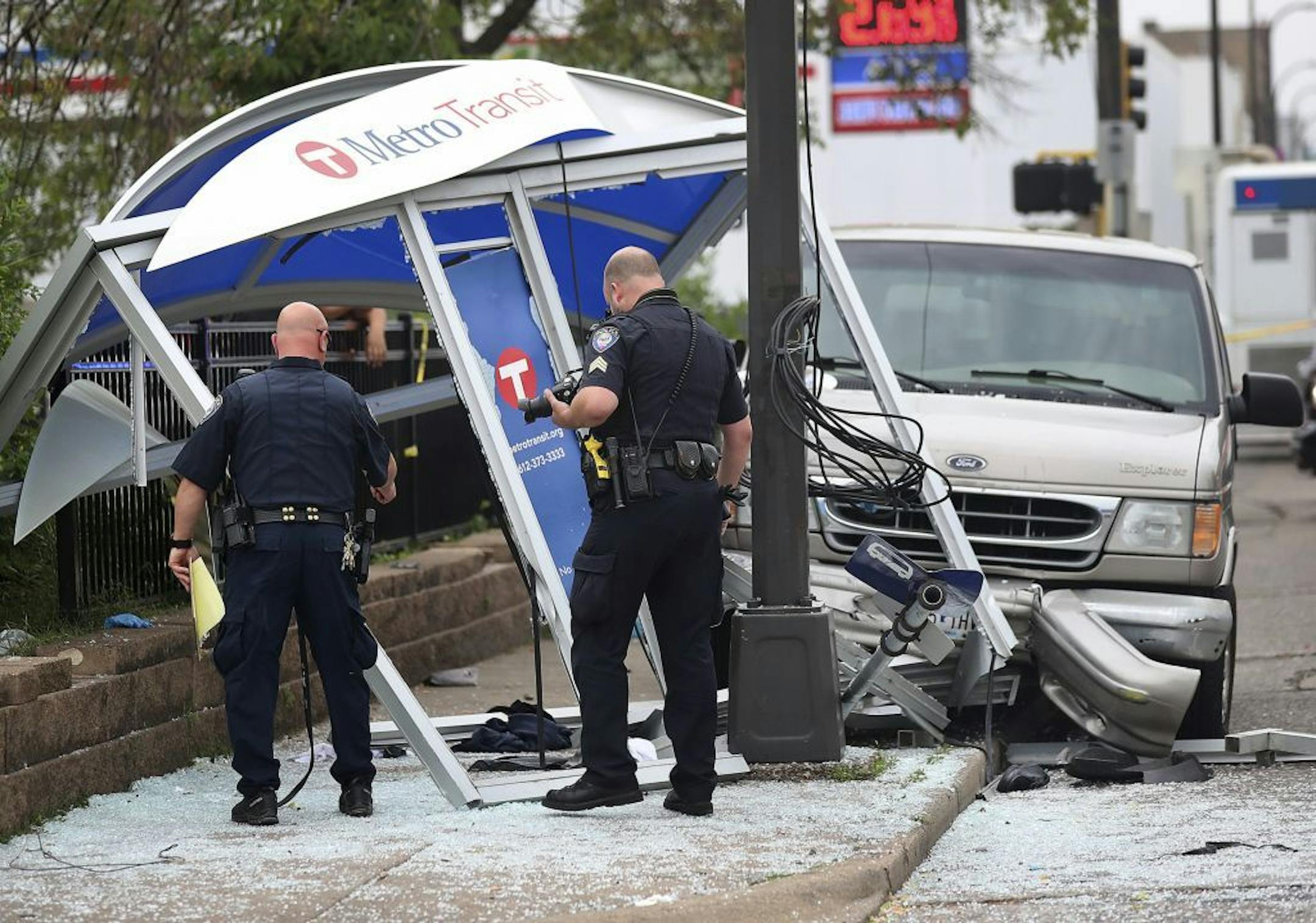 Police look over the scene where a van slammed into a crowded bus stop shelter in north Minneapolis on July 9. George Reeves Jensen of Champlin, who crashed his van into a Minneapolis bus shelter, was charged with five counts of criminal vehicular operation. But Hennepin County Attorney Mike Freeman says the injuries resulting from Jensen's driving raise questions about "more severe charges."