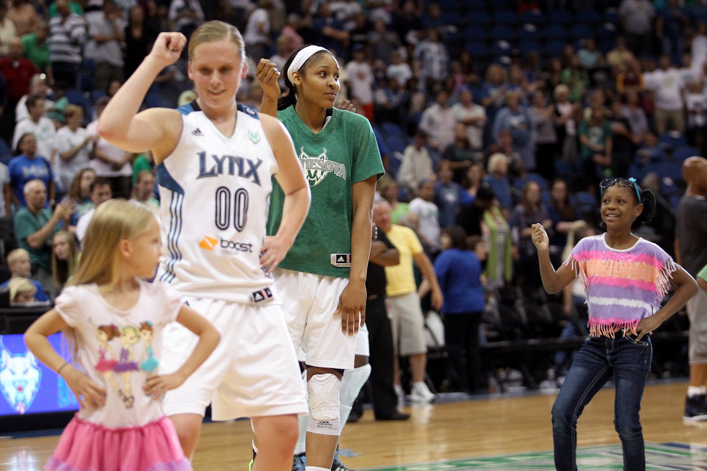 Minnesota's Lindsey Moore (00) and Maya Moore (23) dance with kids on the court after their win of the New York Liberty vs. Minnesota Lynx basketball game at the Target Center in Minneapolis, Minn., on Sunday, August 18, 2013. The Lynx won the game 88-57. ] (ANNA REED/STAR TRIBUNE) anna.reed@startribune.com (cq)