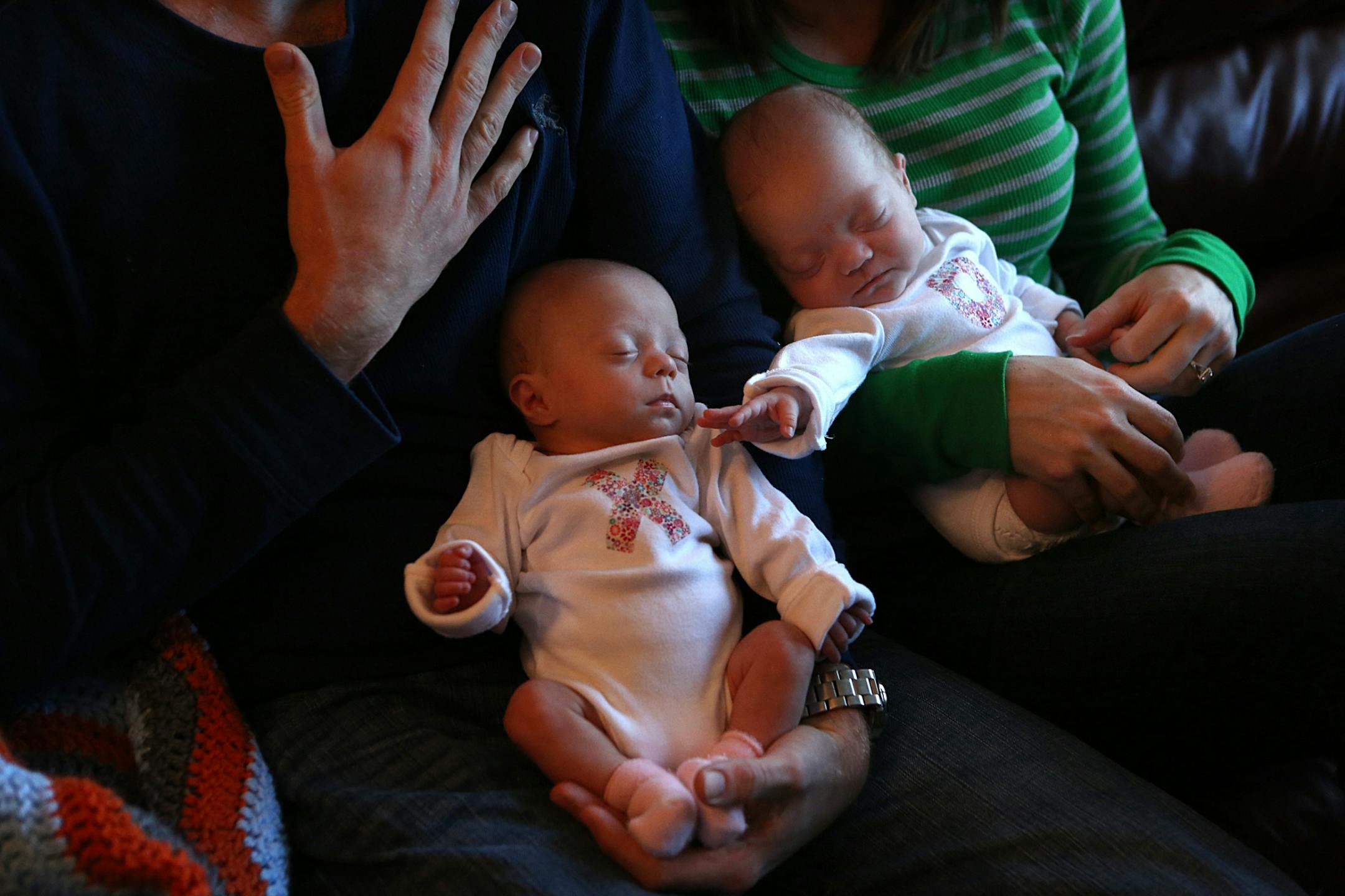 Twins Bryn (held by dad, Nick, left) and Nora (held by mom, Sara) Windschitl, are now at home with their parents.