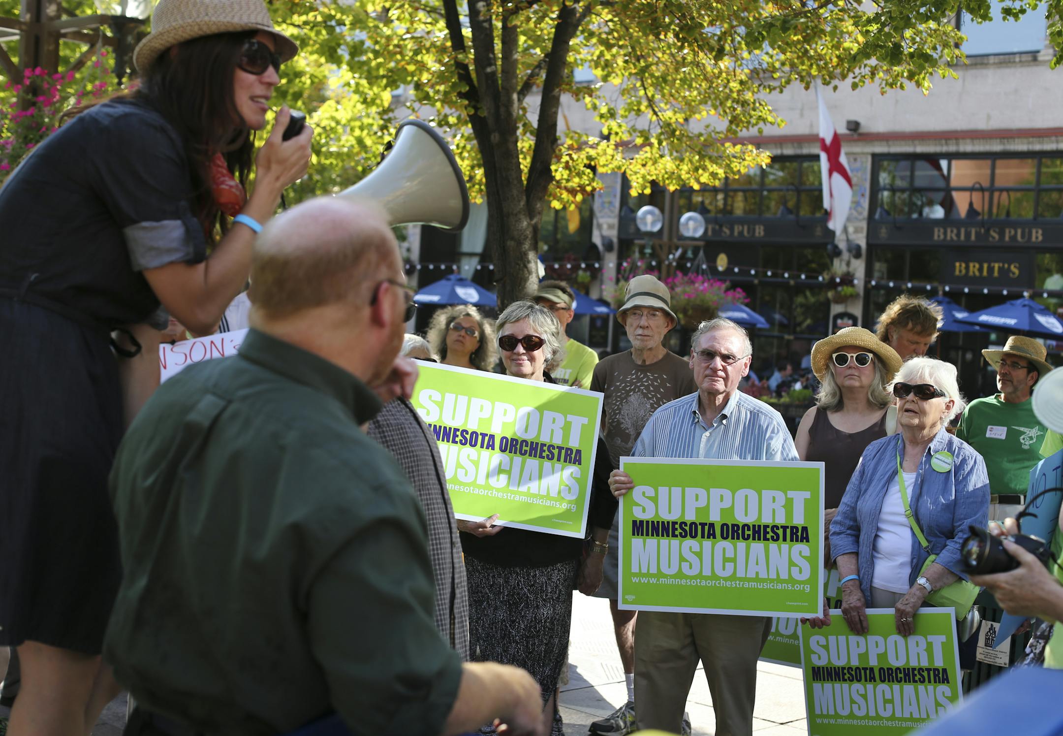 People holding signs listened to a speaker during a rally in support of Minnesota Orchestra musicians who have been locked out for nearly a year, in Minneapolis, Minn., on Friday, September 6, 2013. ] (RENEE JONES SCHNEIDER • reneejones@startribune.com)