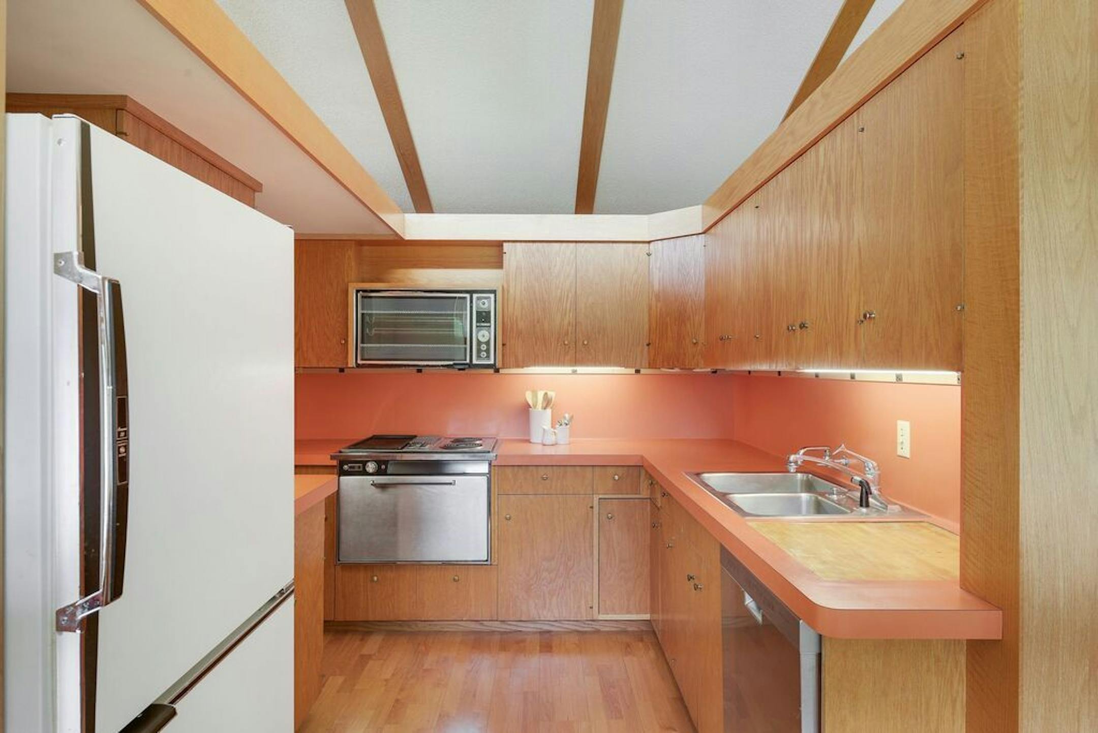 The kitchen has its original orange Formica countertops.