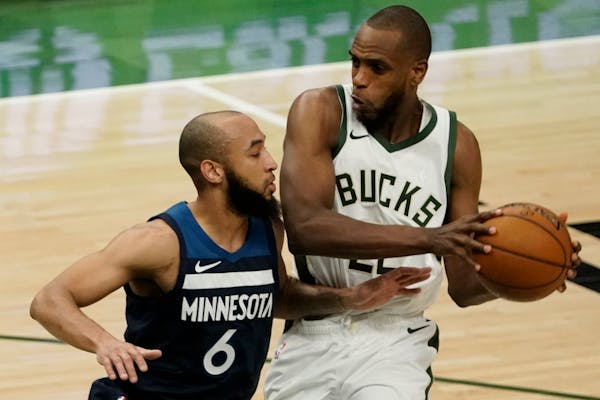 Khris Middleton of the Bucks tried to drive past Timberwolves guard Jordan McLaughlin on Tuesday night in Milwaukee.