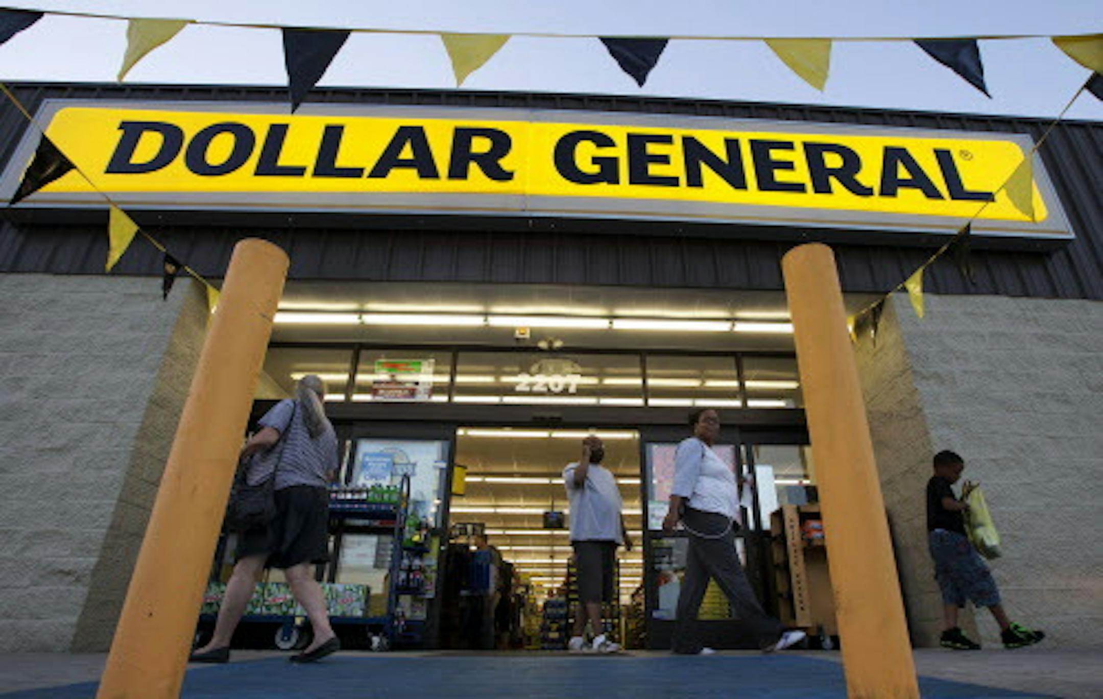 FILE - In this Wednesday, Sept. 25, 2013, file photo, customers exit a Dollar General store, in San Antonio. There&#xed;s now a bidding war for Family Dollar, with Dollar General offering about $9.7 billion for the discounter in an effort to trump Dollar Tree&#xed;s bid of $8.5 billion. (AP Photo/Eric Gay, File)
