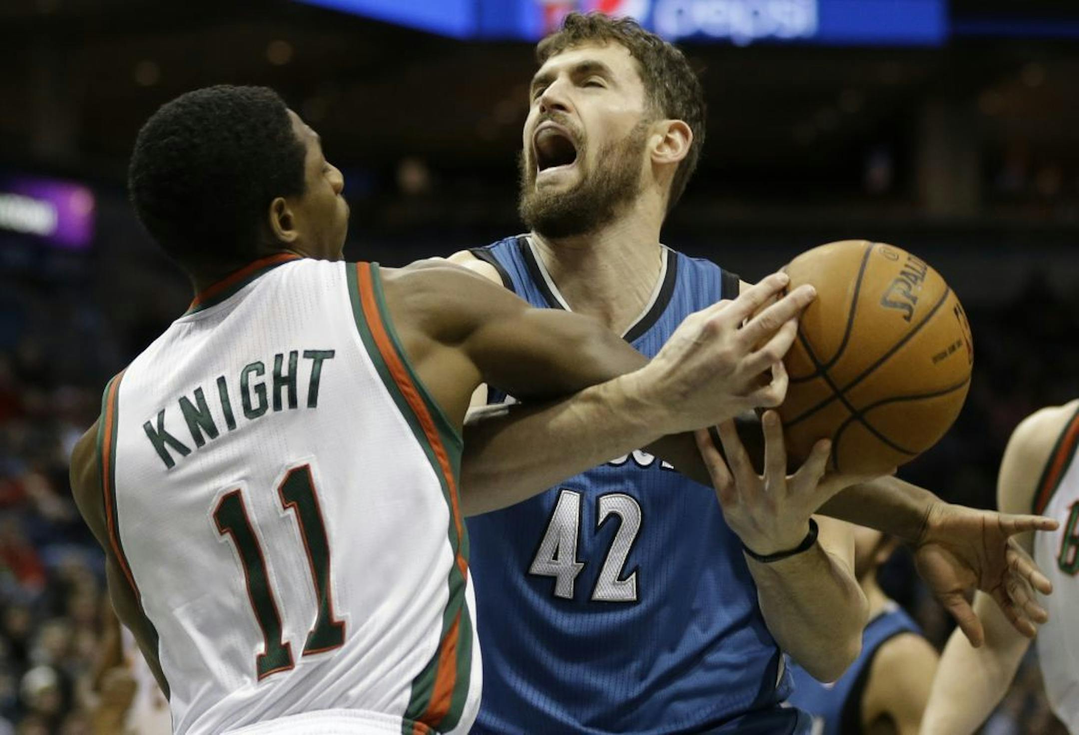 Milwaukee Bucks' Brandon Knight (11) fouls Minnesota Timberwolves' Kevin Love (42) during the first half of an NBA basketball game, Saturday, Dec. 28, 2013, in Milwaukee.