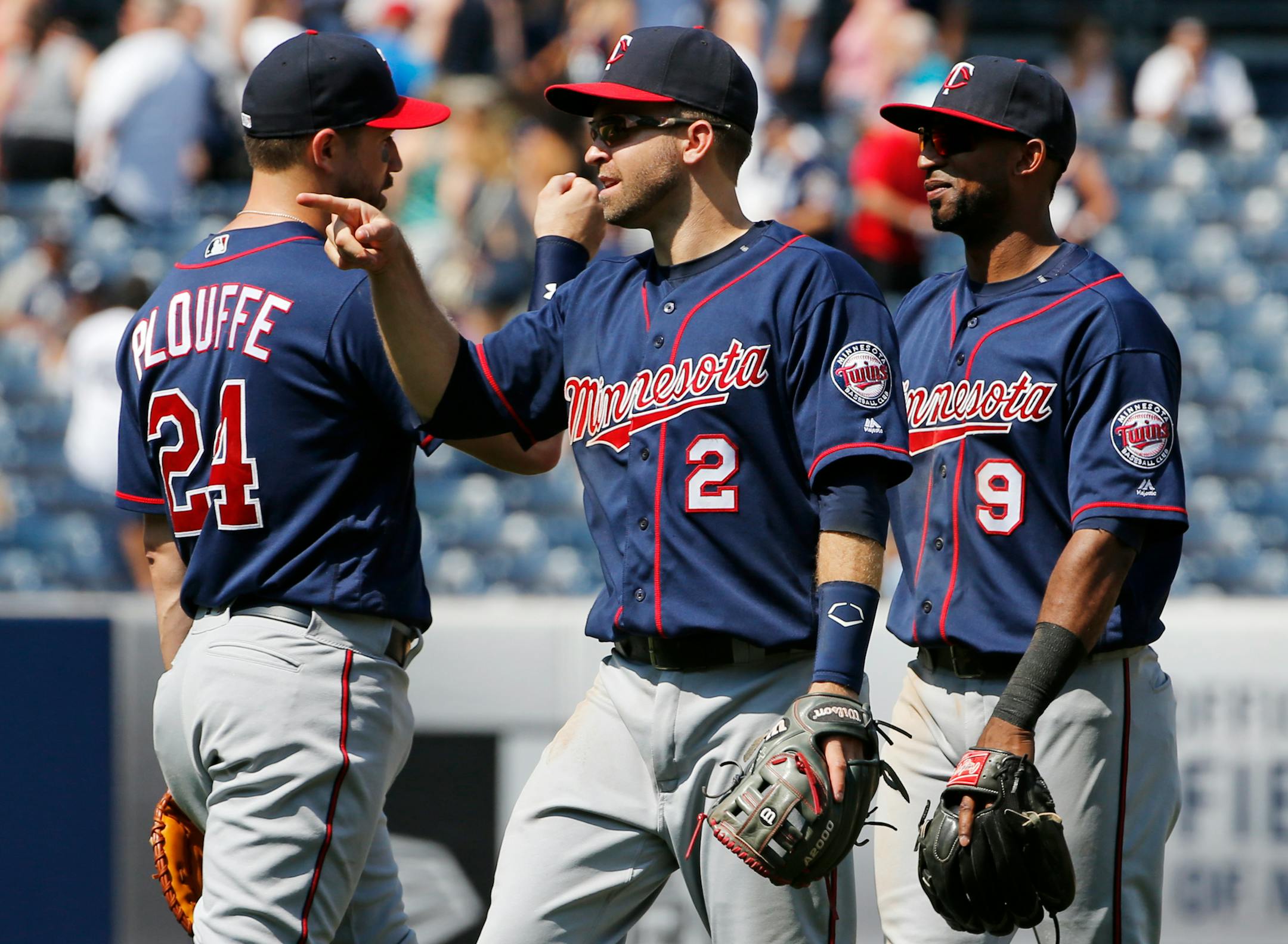 Minnesota Twins first baseman Trevor Plouffe (24), second baseman Brian Dozier (2) and third baseman Eduardo Nunez (9) celebrate after the Twins defeated the New York Yankees 7-1 in a baseball game in New York, Sunday, June 26, 2016. (AP Photo/Kathy Willens)