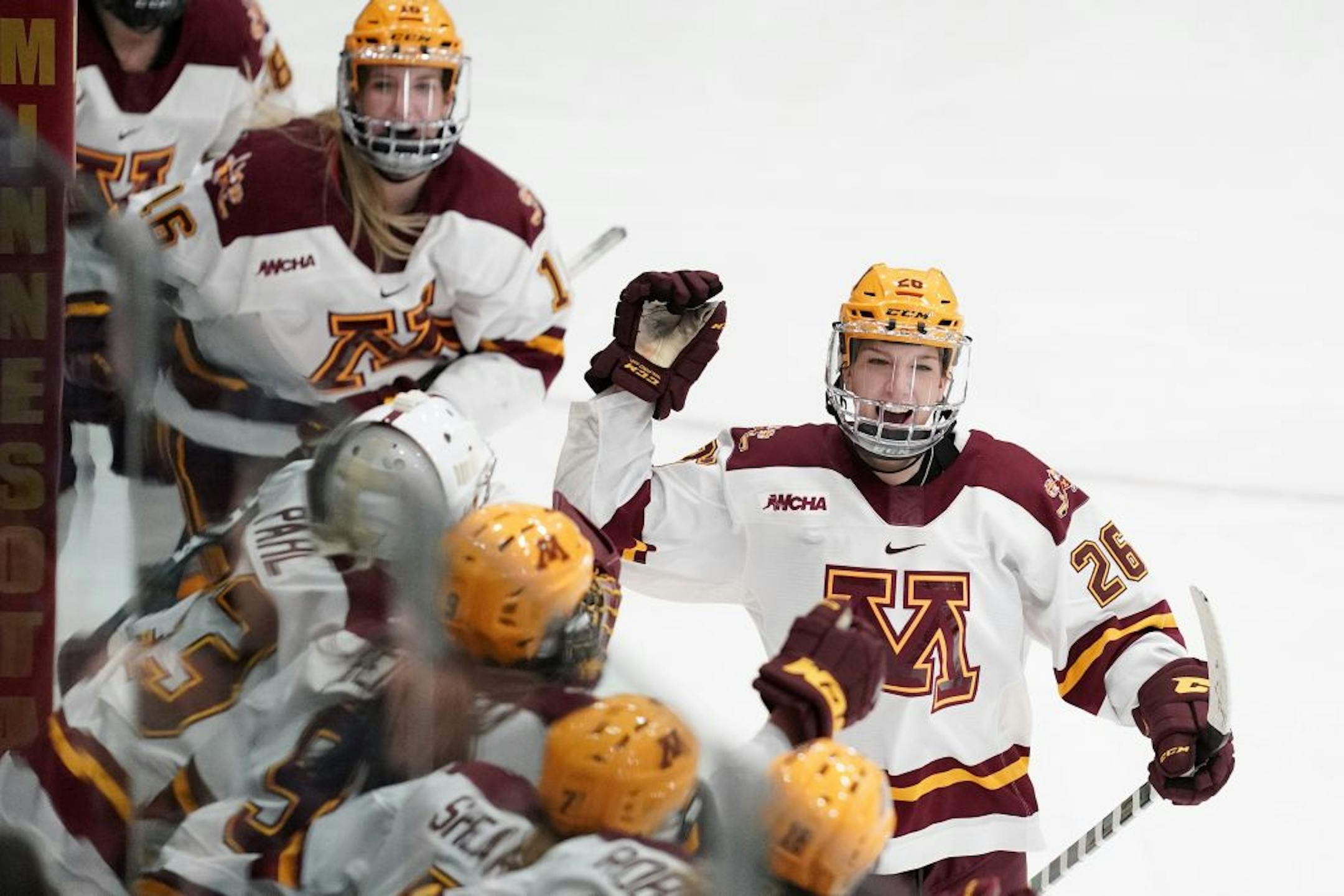 Minnesota Golden Gophers forward Sarah Potomak (26) celebrated with her teammates on the bench after she scored a goal on Wisconsin Badgers goaltender Kristen Campbell (35) in the second period of Saturday's game.