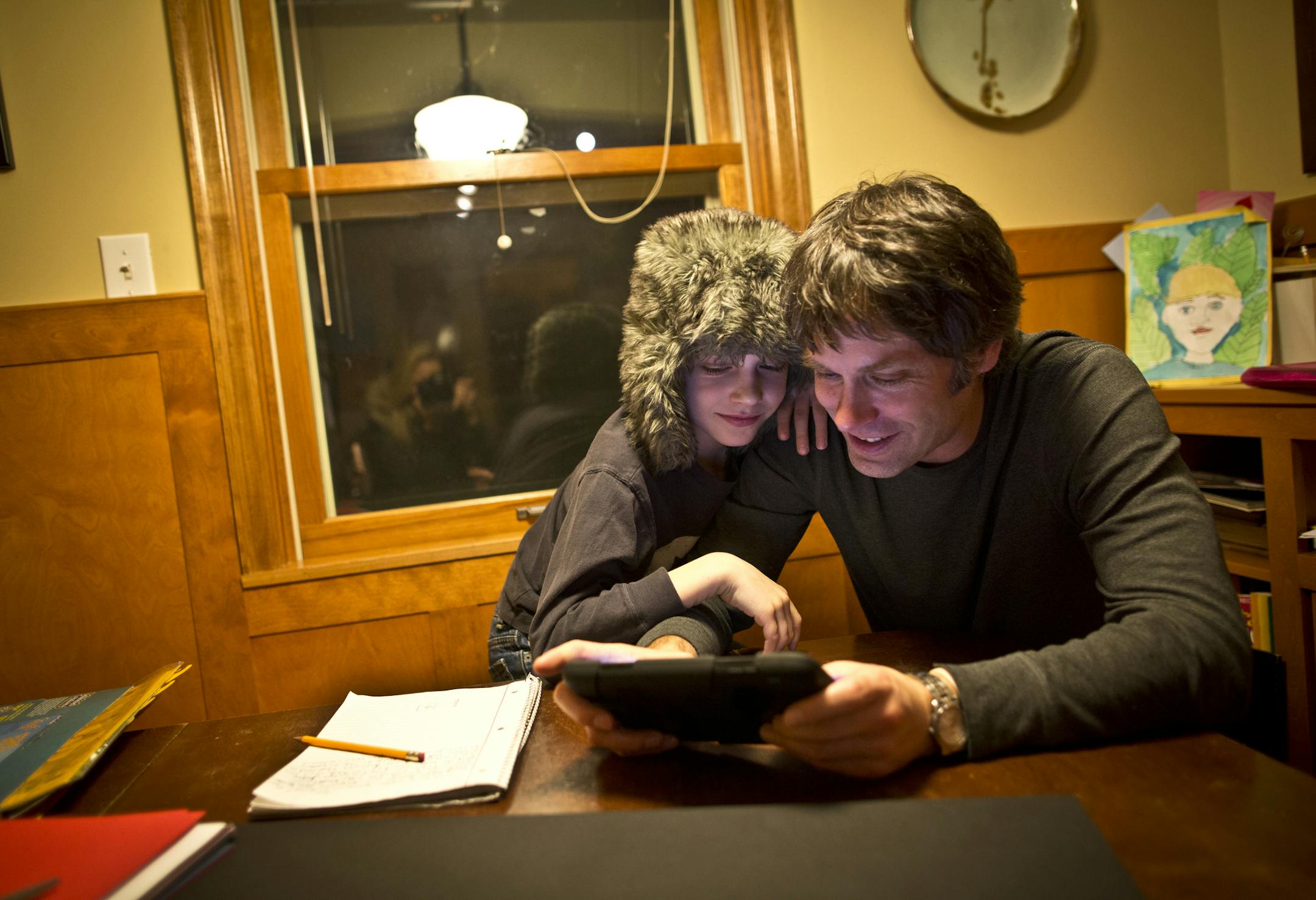 Single dad Brett Mortenson and his 9-year-old son Grant did research on an iPad mini for a school project on rechargeable batteries on Monday, February 26, 2013, at home in Minneapolis, Minn. ] (RENEE JONES SCHNEIDER * reneejones@startribune.com)