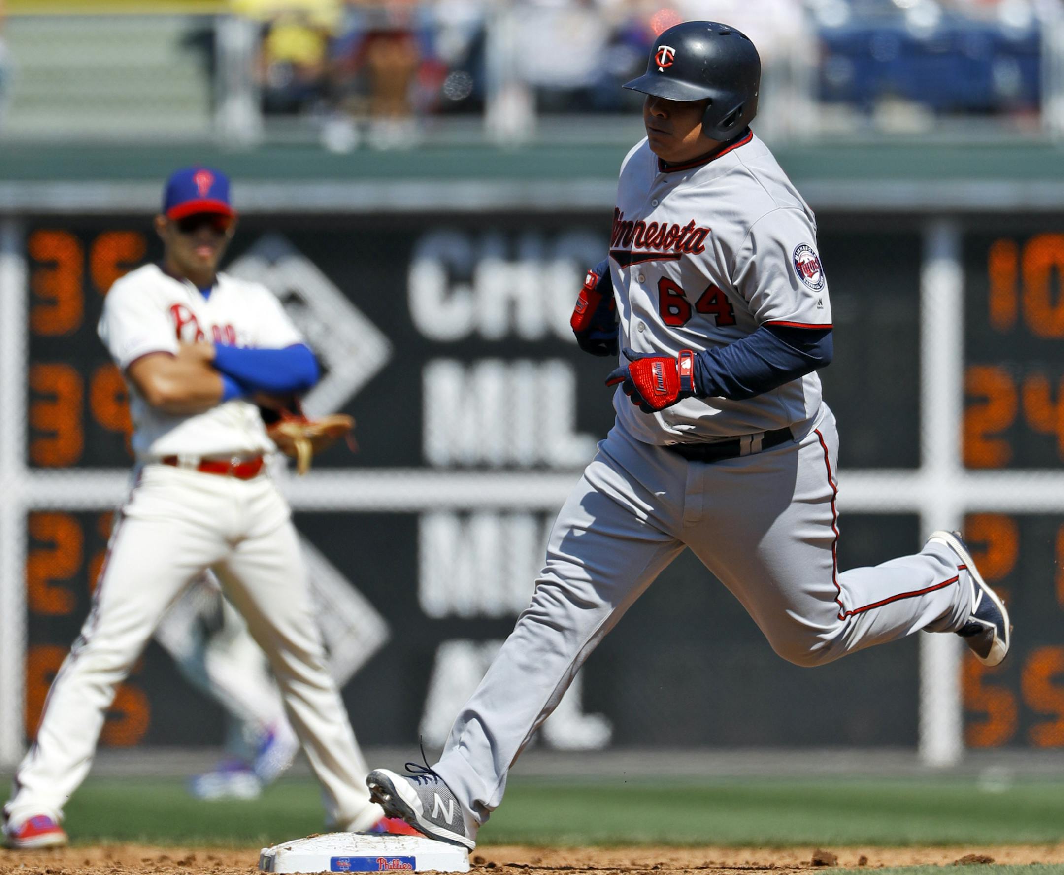 Minnesota Twins' Willians Astudillo, right, rounds the bases past Philadelphia Phillies second baseman Cesar Hernandez after hitting a home run off starting pitcher Jake Arrieta during the third inning of a baseball game, Saturday, April 6, 2019, in Philadelphia. (AP Photo/Matt Slocum)