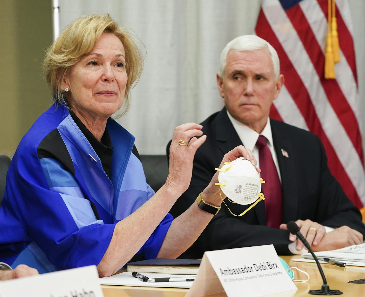 FILE - In this March 5, 2020, file photo, Dr. Deborah Birx, Ambassador and White House coronavirus response coordinator, holds a 3M N95 mask as Vice President Mike Pence visits 3M headquarters in Maplewood, Minn., in a meeting with 3M leaders and Minnesota Gov. Tim Walz to coordinate response to the COVID-19 virus. A review of federal purchasing contracts by The Associated Press shows federal agencies waited until mid-March to begin placing bulk orders of N95 respirator masks, mechanical ventila