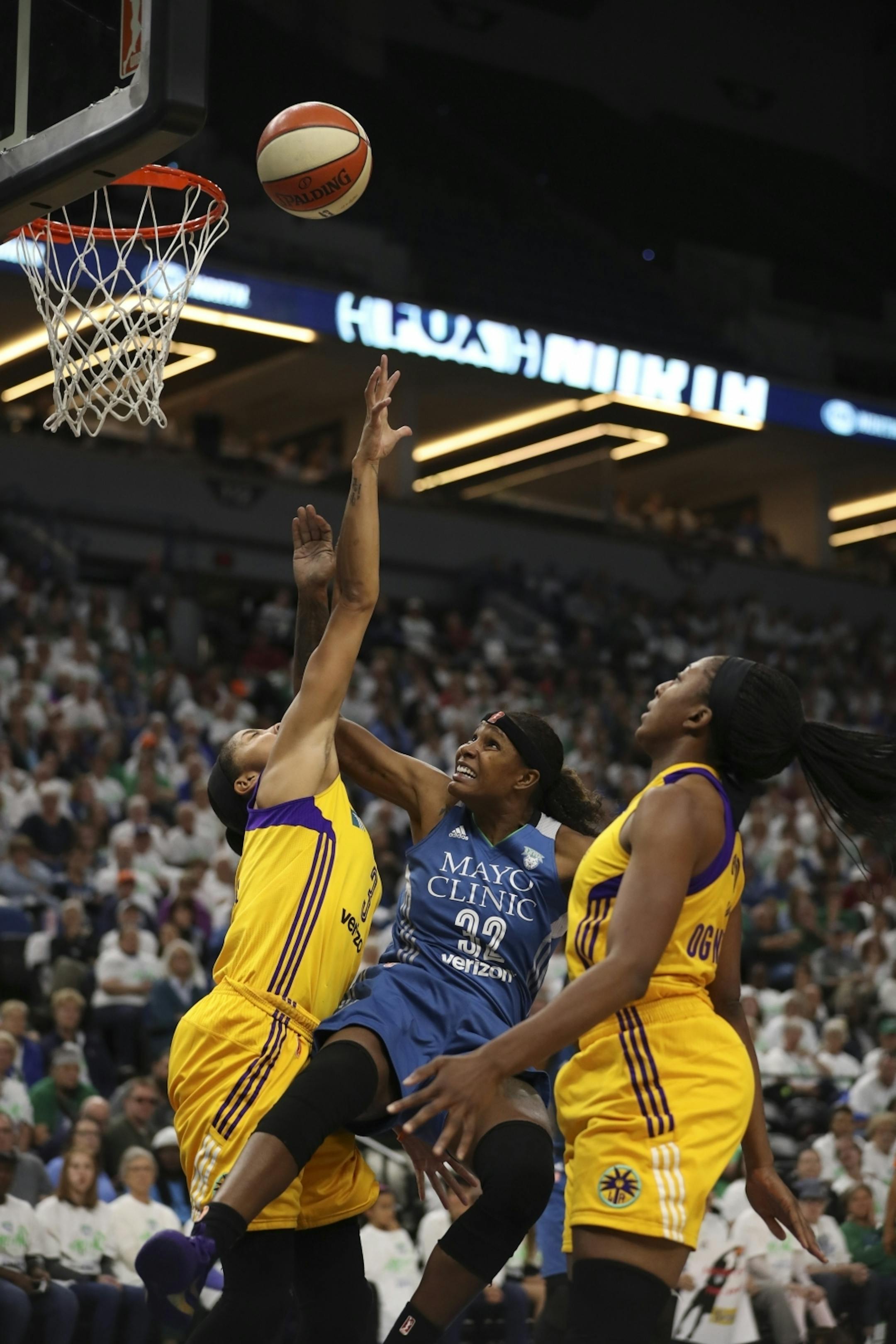 Minnesota Lynx forward Rebekkah Brunson (32) was fouled by Los Angeles Sparks forward Candace Parker (3) as she shot in the third quarter. At right was Los Angeles Sparks forward Nneka Ogwumike (30).