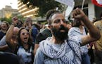 Anti-government protesters shout slogans, as they march during a protest against the central bank and the Lebanese government, in Beirut, Lebanon, Thu