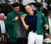 Bubba Watson helps Jordan Spieth put on his green jacket after winning the Masters golf tournament Sunday, April 12, 2015, in Augusta, Ga. (AP Photo/M