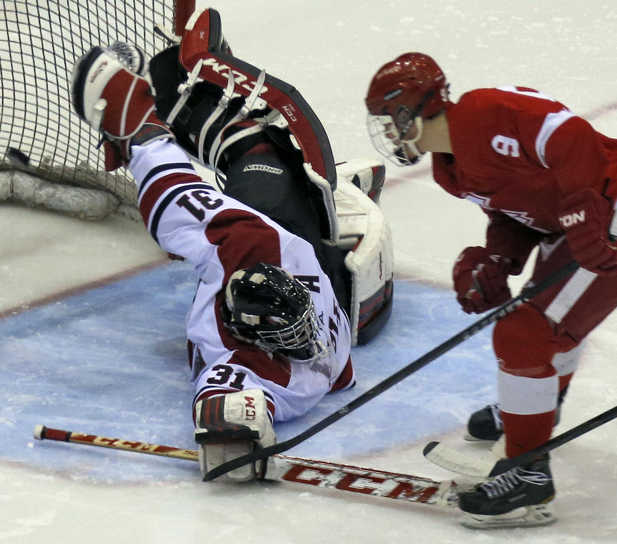 Eagles goalie Jake Gerdes made a diving save of a shot on goal by Red Knights Zack Hale (9) in 2nd period action. [ Class 2A Boys Hockey Section Finals - Eden Prairie Eagles vs. Benilde St.-Margaret's Red Knights. (MARLIN LEVISON/STARTRIBUNE(mlevison@startribune.com)
