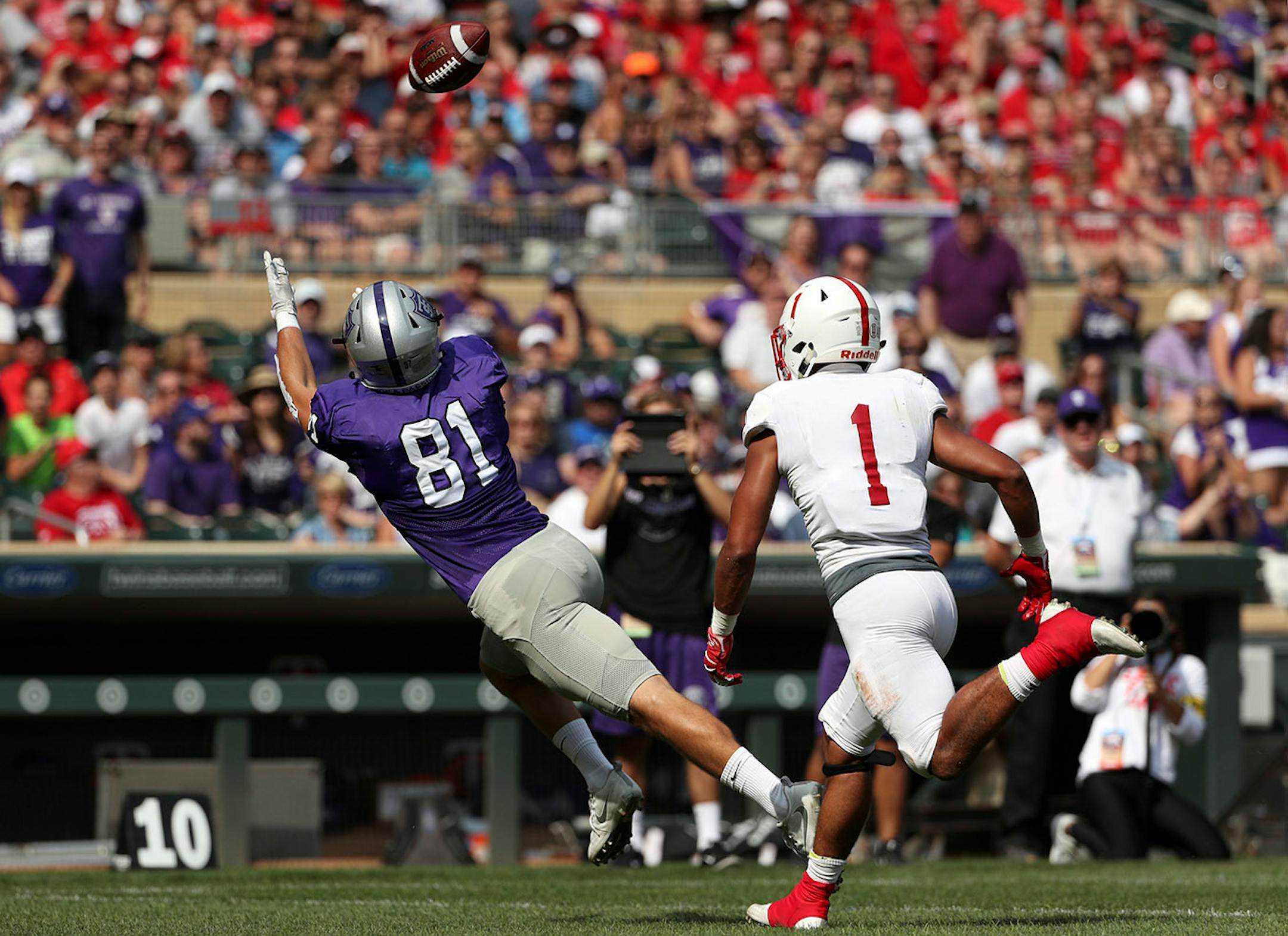University of St. Thomas tight end Grant Slavik (81) reached out for a long pass as St. John's University defensive back Max Jackson (1) raced to defend in the first half.