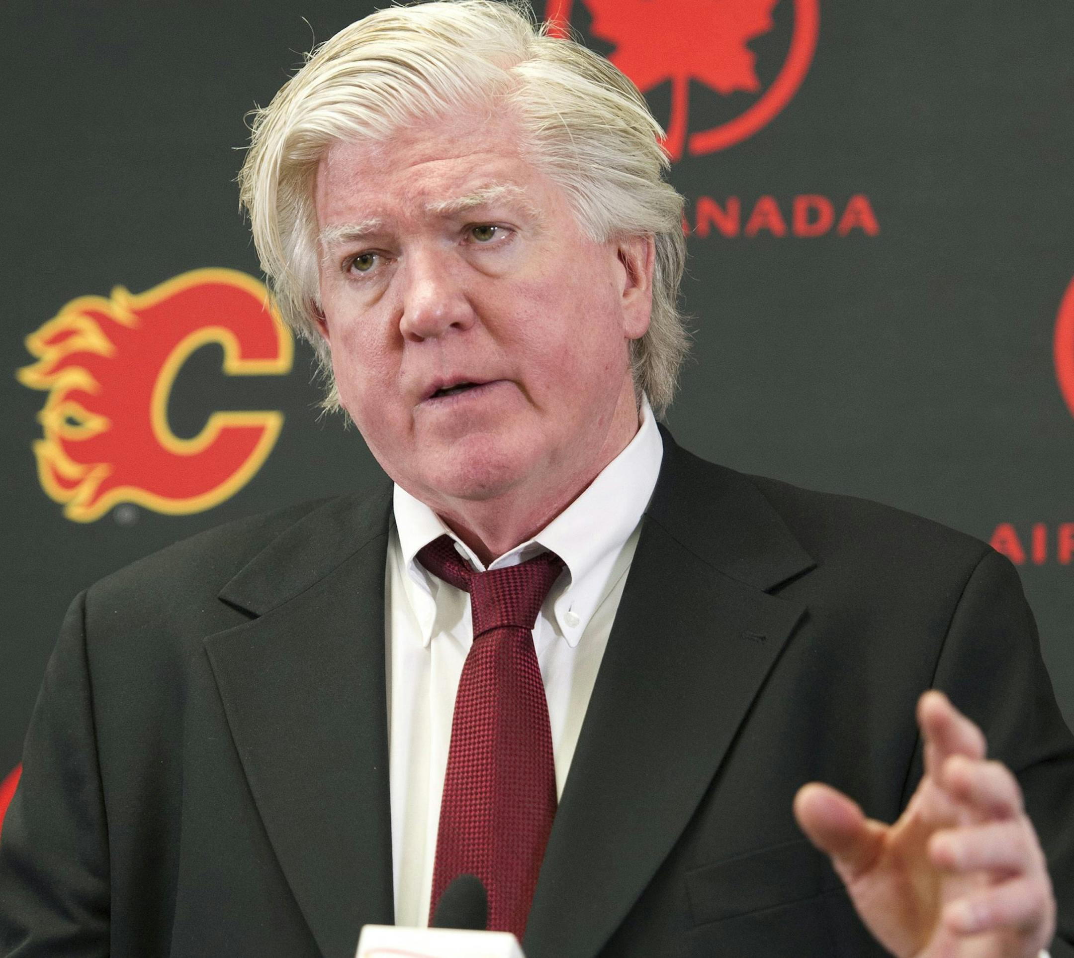 Brian Burke, Calgary Flames' president of hockey operations, announces the firing of general manager Jay Feaster and assistant general manager John Weisbrod during a NHL hockey news conference Thursday, Dec. 12, 2013, in Calgar, Alberta. Burke will serve as acting general manager. (AP Photo/The Canadian Press, Larry MacDougal)